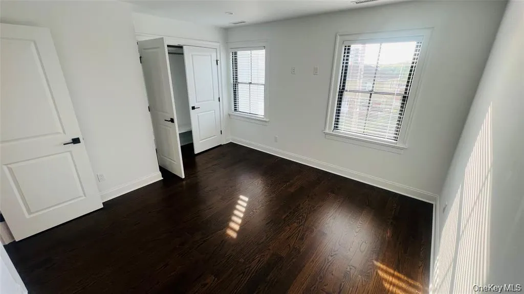 Unfurnished bedroom with dark wood-type flooring and a closet Unfurnished bedroom with dark wood-type flooring and a closet
