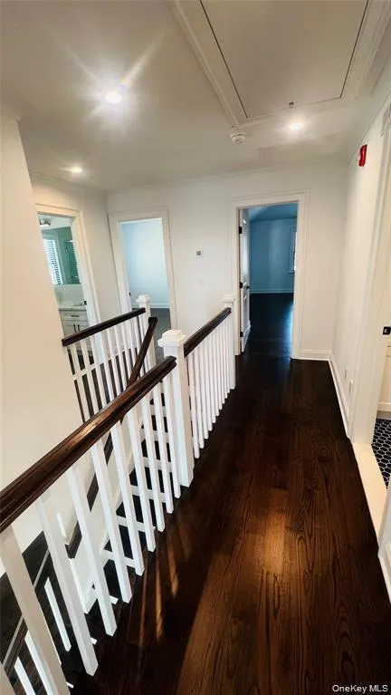 Hall with an upstairs landing, dark wood-style flooring, and attic access Hall with an upstairs landing, dark wood-style flooring, and attic access