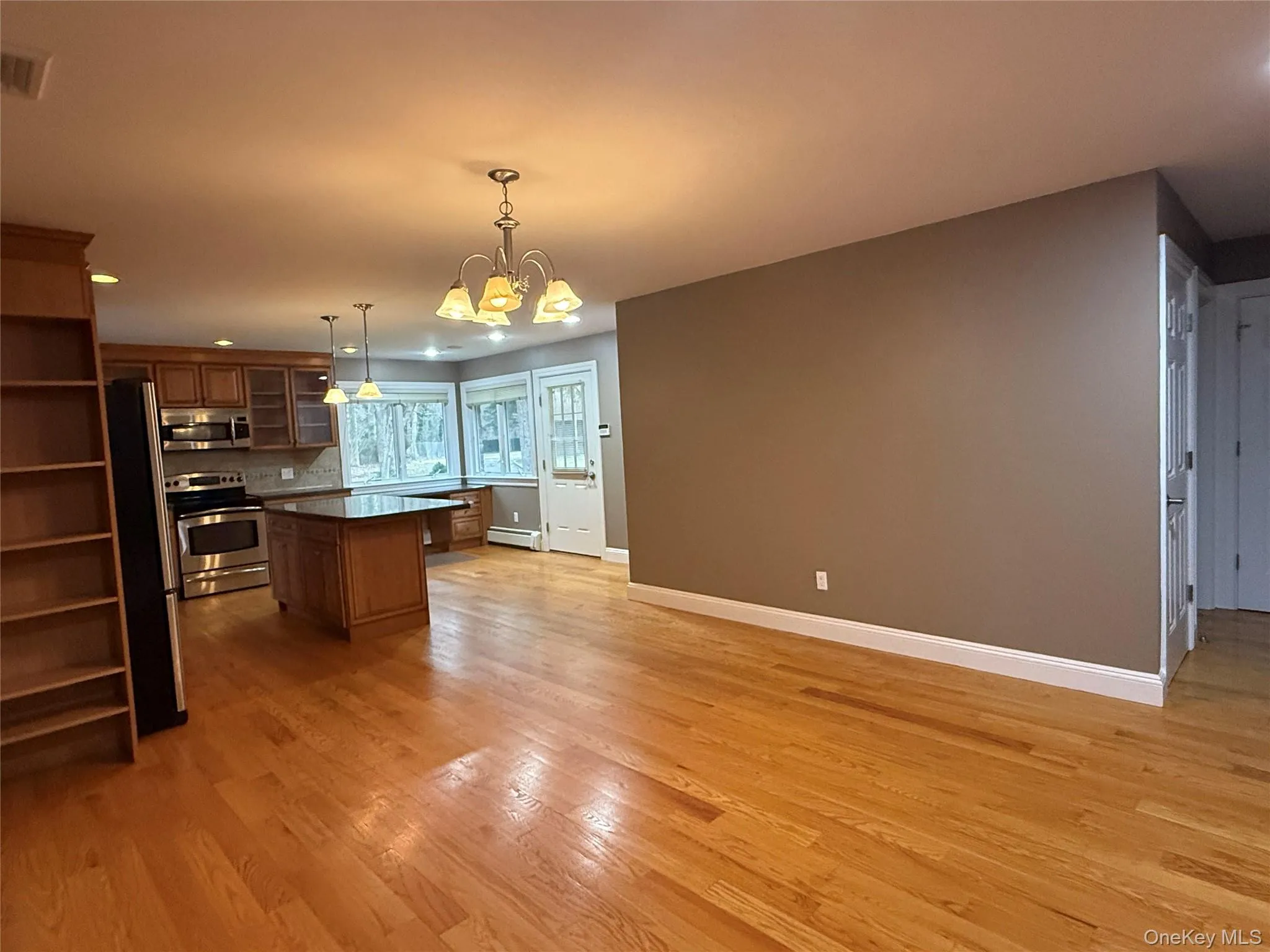 Kitchen with glass insert cabinets, hanging light fixtures, open shelves, appliances with stainless steel finishes, and recessed lighting Kitchen with glass insert cabinets, hanging light fixtures, open shelves, appliances with stainless steel finishes, and recessed lighting