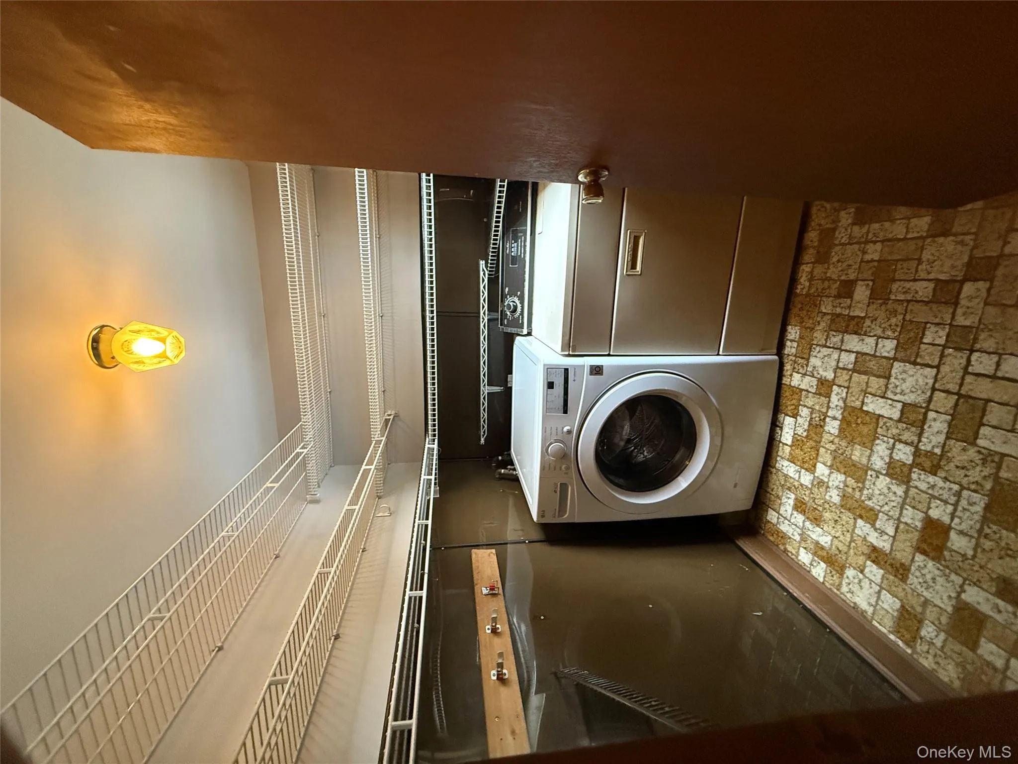 Laundry room featuring brick patterned flooring and washer and clothes dryer Laundry room featuring brick patterned flooring and washer and clothes dryer