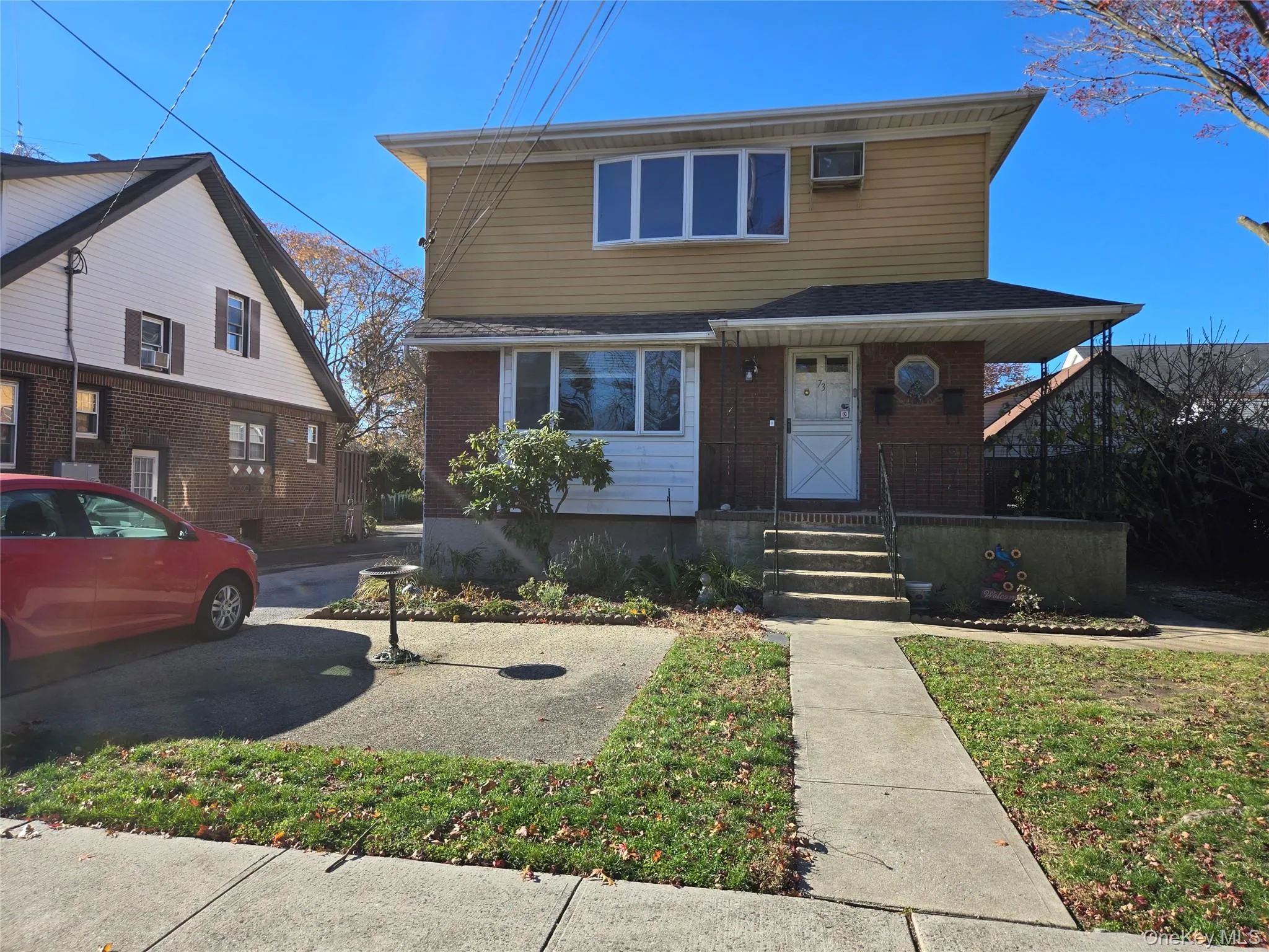 Traditional-style house with a porch, brick siding, and a front yard Traditional-style house with a porch, brick siding, and a front yard