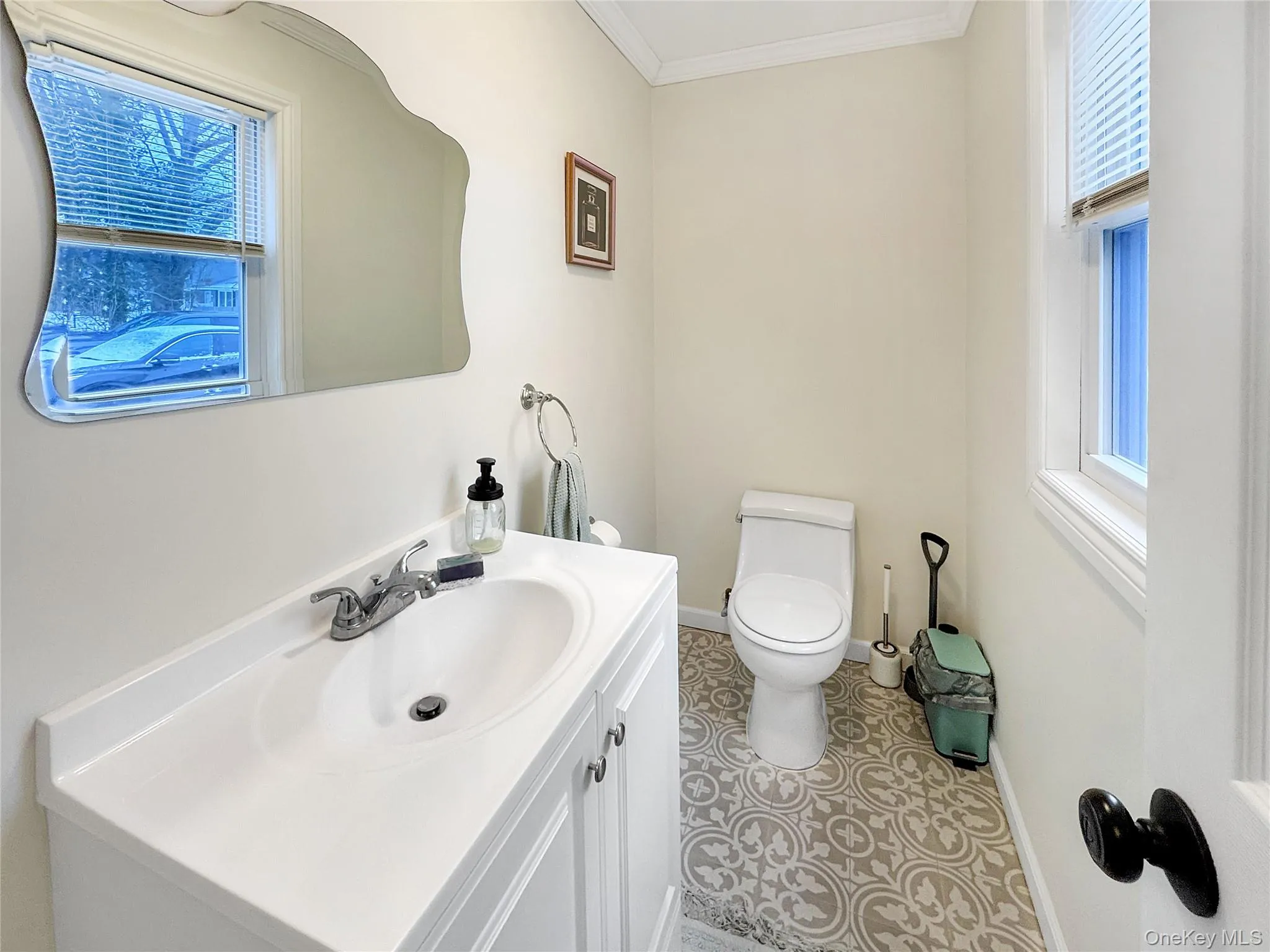 Bathroom with vanity, plenty of natural light, ornamental molding, and light tile patterned floors Bathroom with vanity, plenty of natural light, ornamental molding, and light tile patterned floors