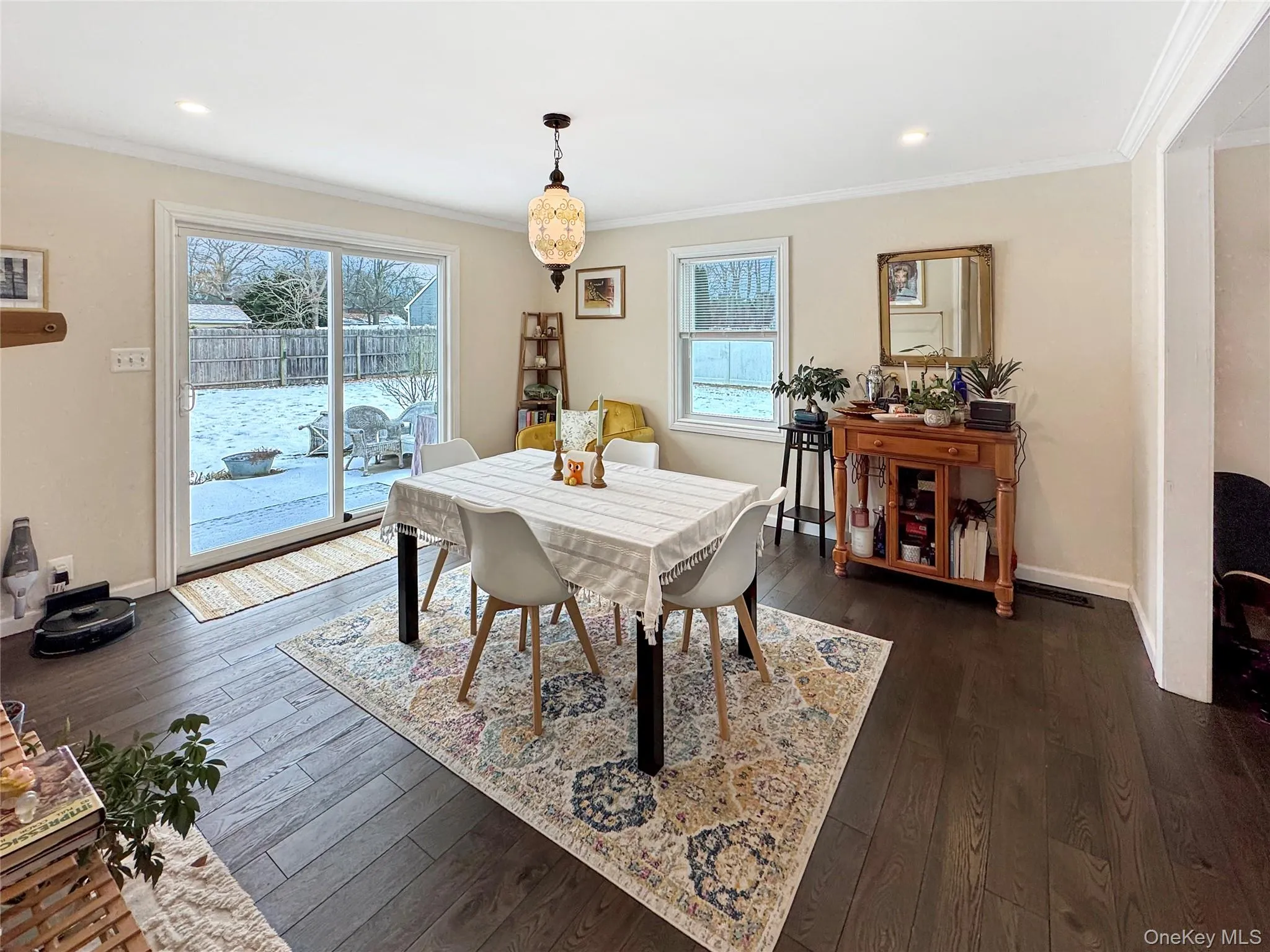 Dining area featuring ornamental molding, dark wood-style flooring, and recessed lighting Dining area featuring ornamental molding, dark wood-style flooring, and recessed lighting