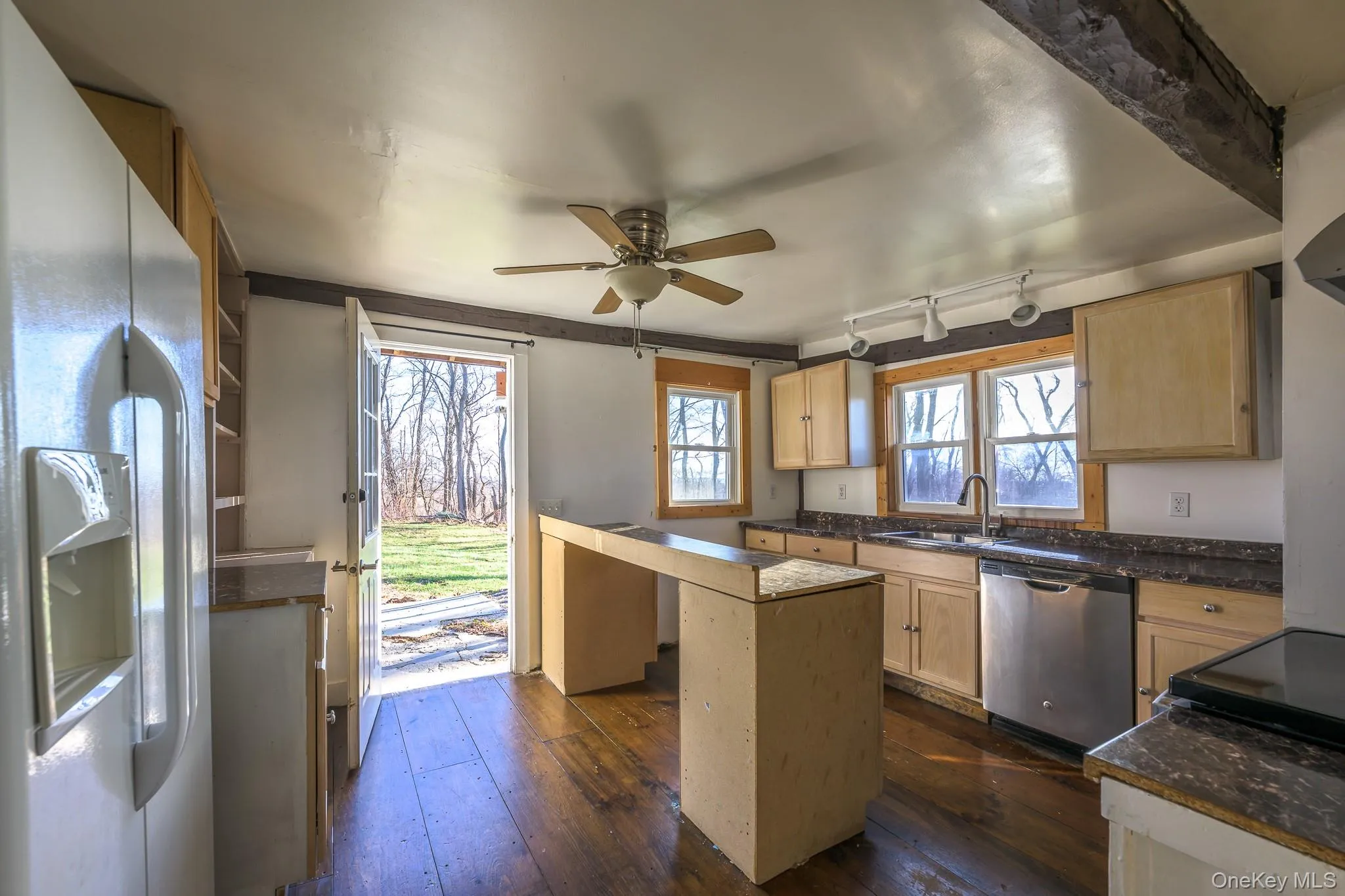 Kitchen with white fridge with ice dispenser, light brown cabinets, dishwasher, dark wood-style floors, and a ceiling fan Kitchen with white fridge with ice dispenser, light brown cabinets, dishwasher, dark wood-style floors, and a ceiling fan