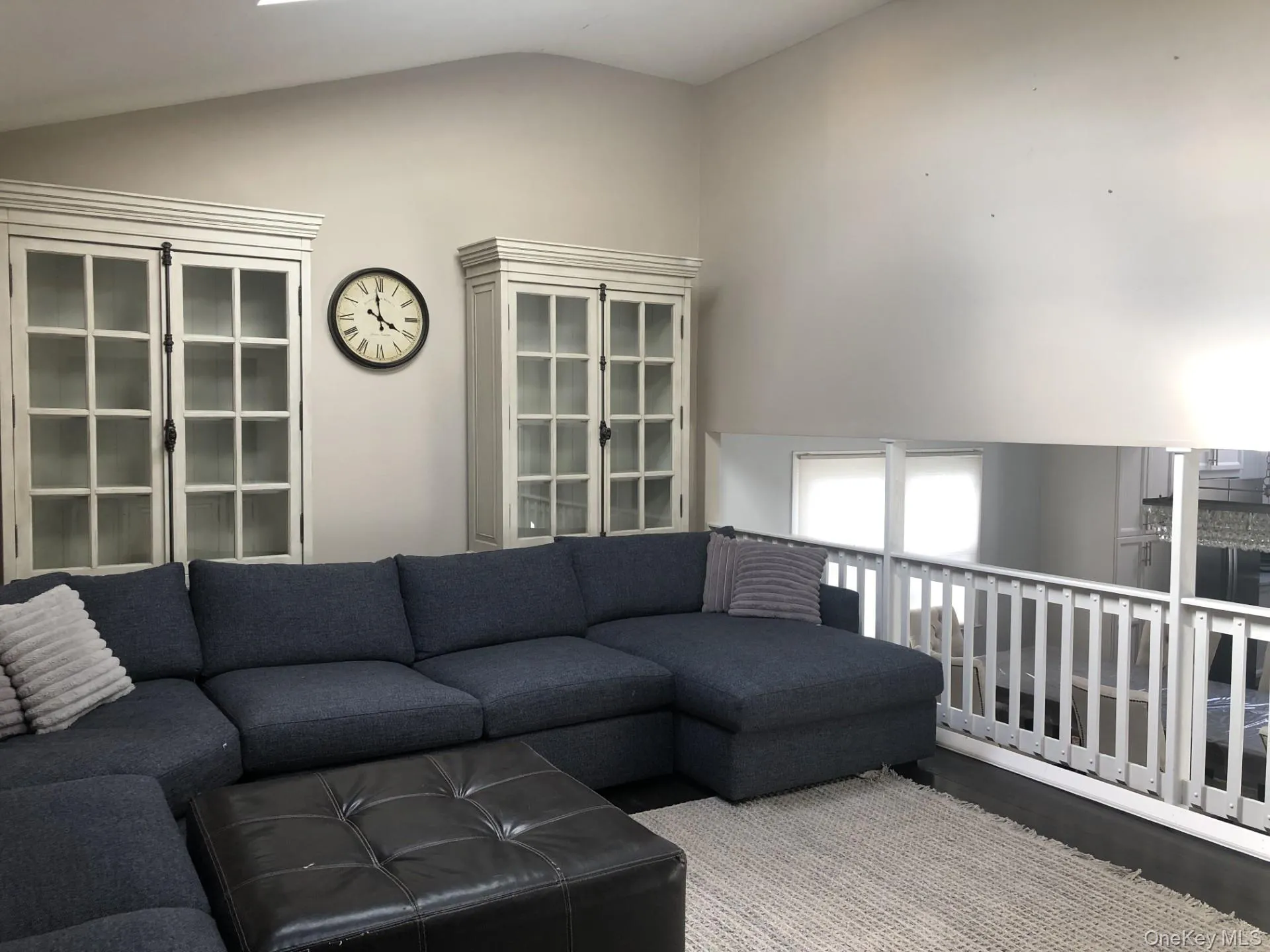 Living room with lofted ceiling with views of open kitchen. Living room with lofted ceiling with views of open kitchen.