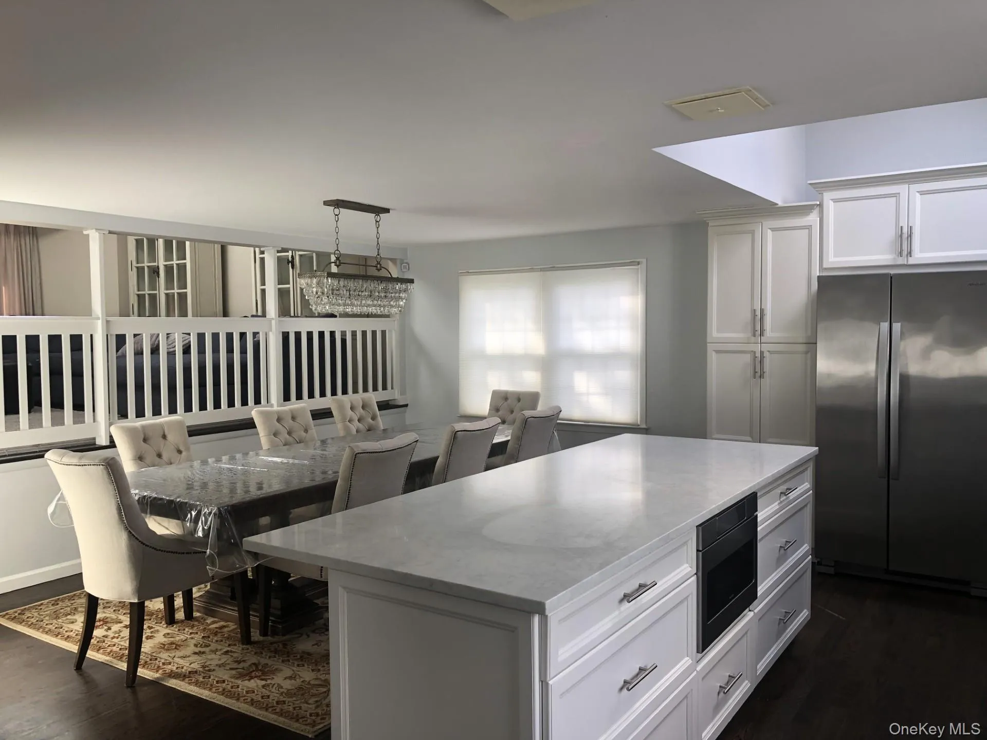 Kitchen with freestanding refrigerator, a kitchen island, light stone counters, dark wood-style floors, and built in microwave Kitchen with freestanding refrigerator, a kitchen island, light stone counters, dark wood-style floors, and built in microwave