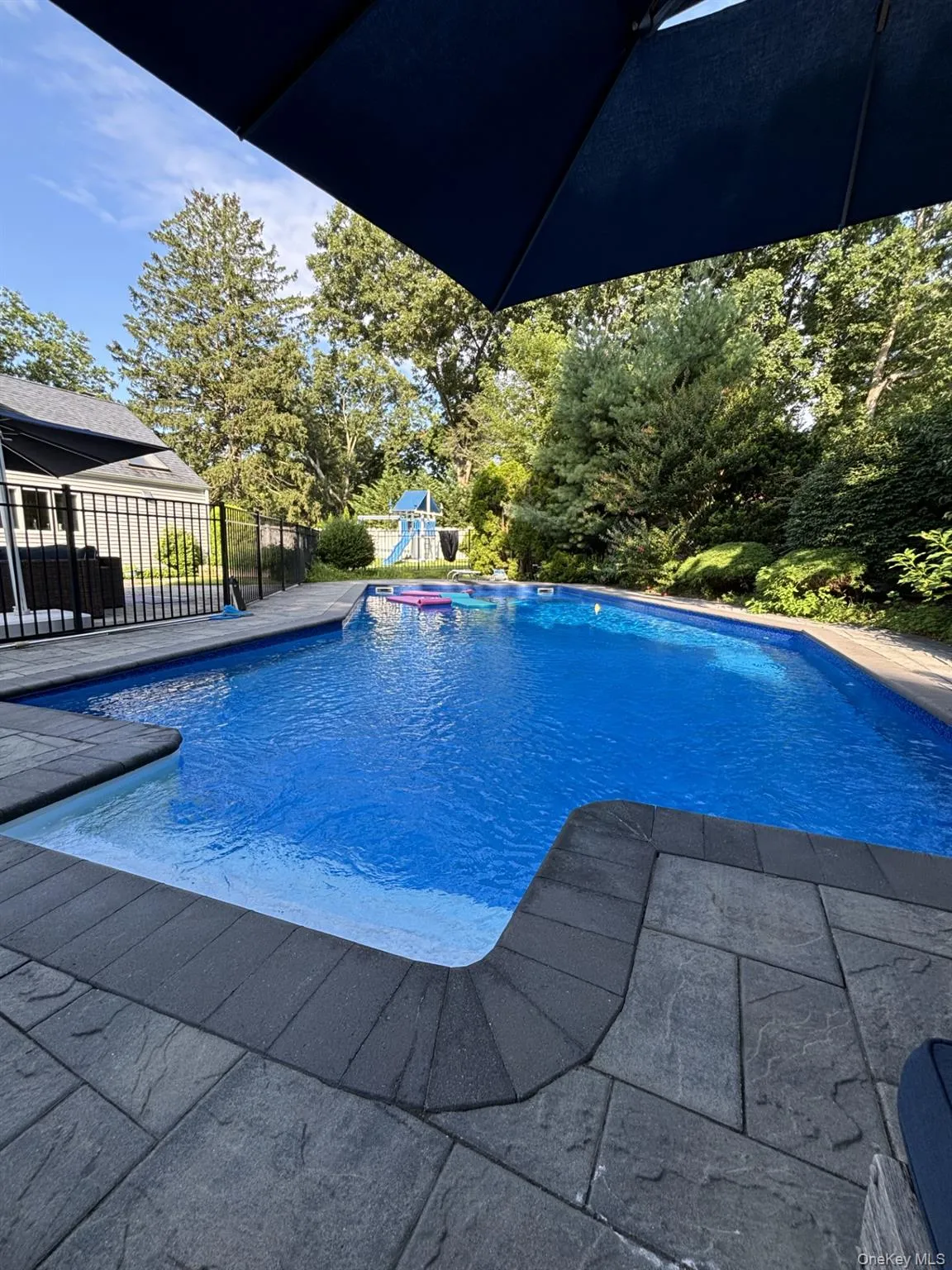 View of pool featuring fence, a fenced in pool, and a playground View of pool featuring fence, a fenced in pool, and a playground