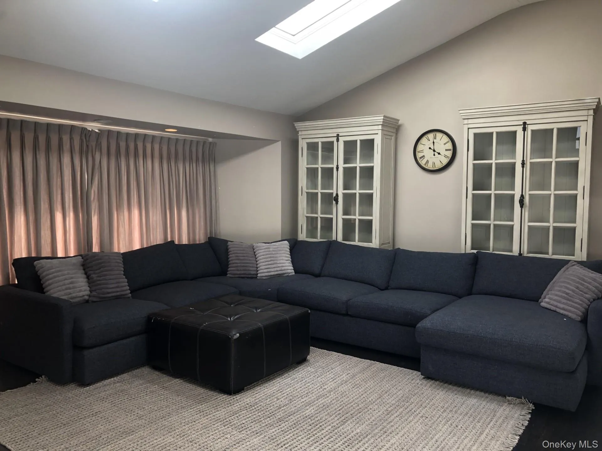 Living room featuring lofted ceiling with skylight Living room featuring lofted ceiling with skylight