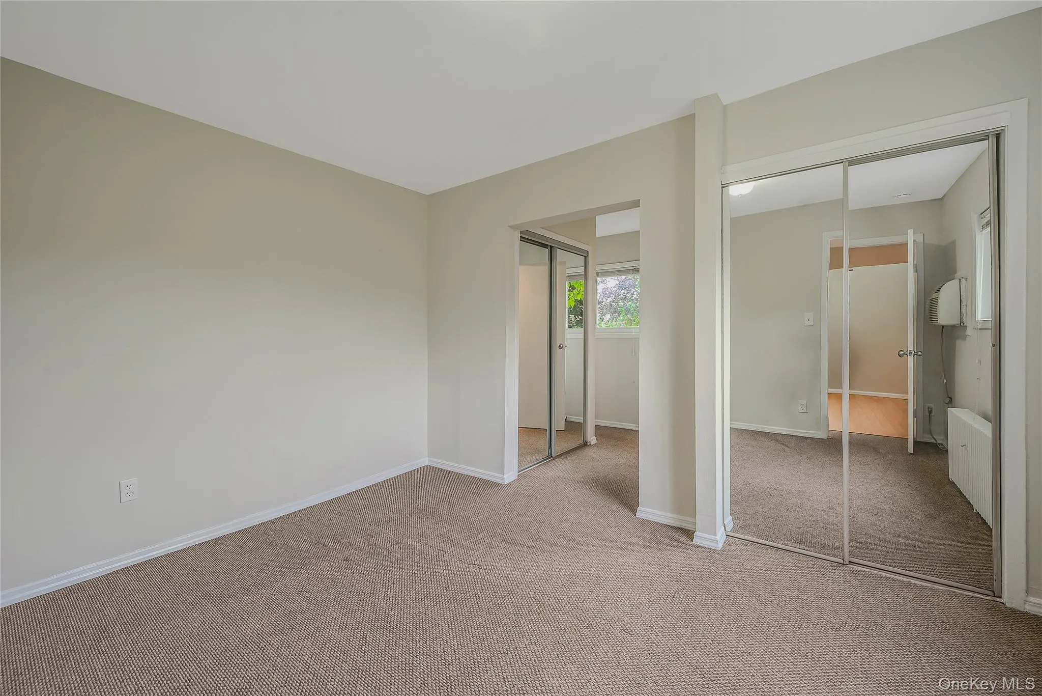 Primary bedroom featuring multiple closets and carpet flooring Primary bedroom featuring multiple closets and carpet flooring