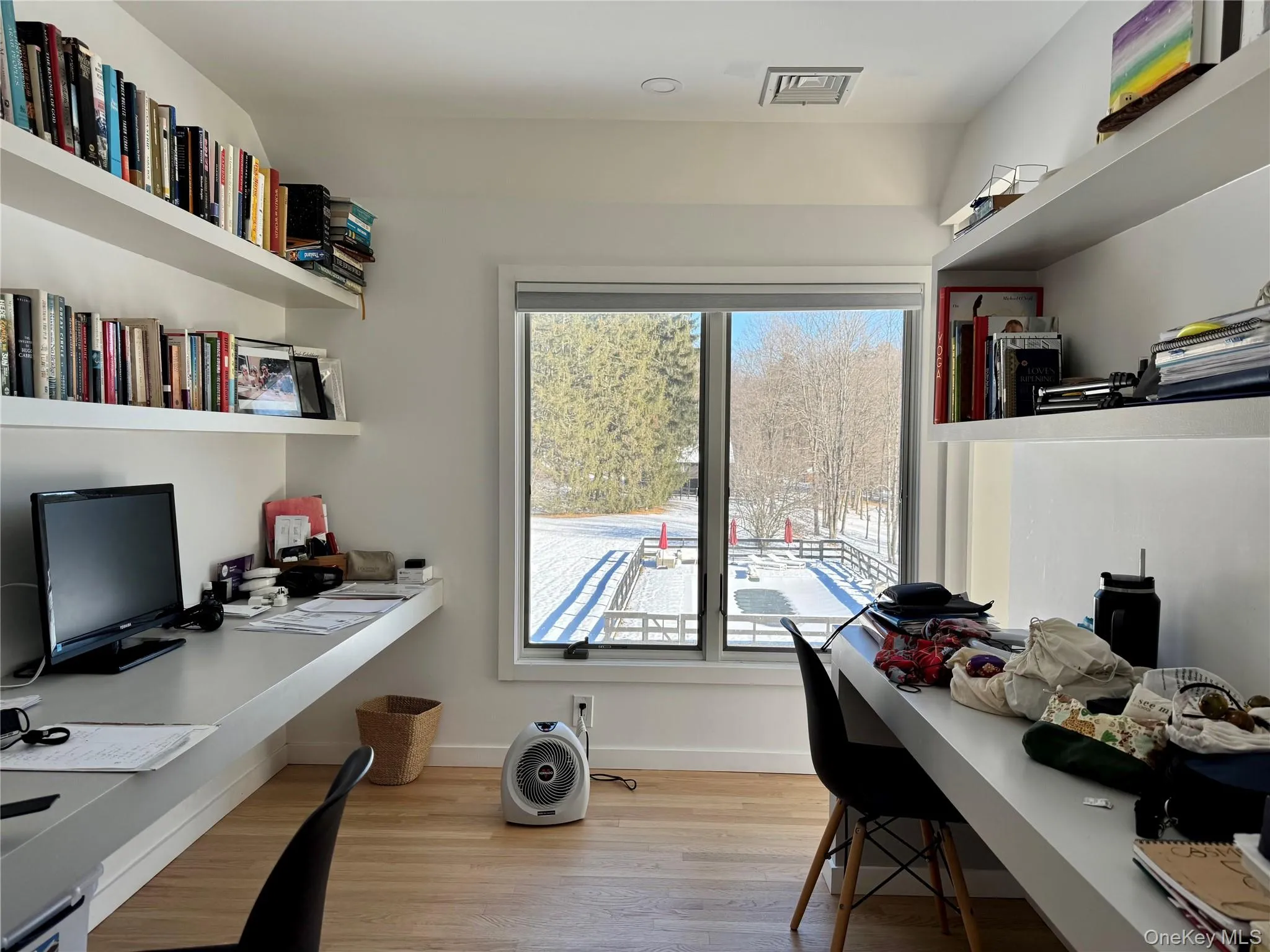 Office space featuring light wood floors, built in desks and lots of light Office space featuring light wood floors, built in desks and lots of light