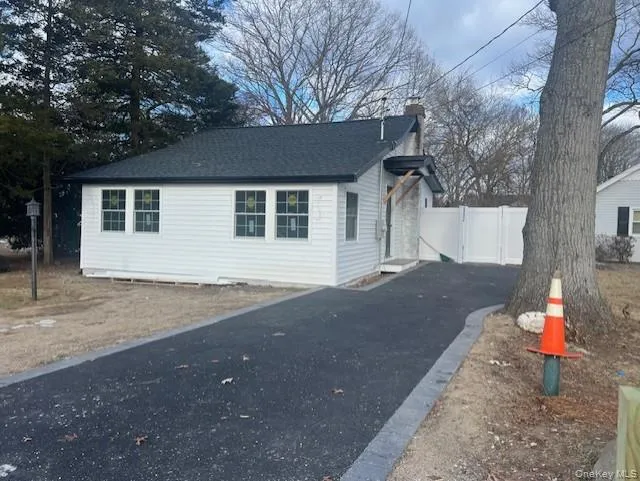 View of side of property with a chimney, roof with shingles, and driveway View of side of property with a chimney, roof with shingles, and driveway