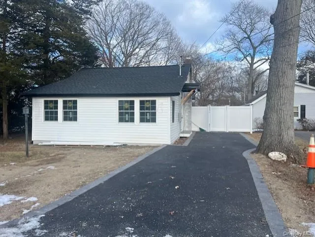 View of side of home featuring a chimney, driveway, and roof with shingles View of side of home featuring a chimney, driveway, and roof with shingles