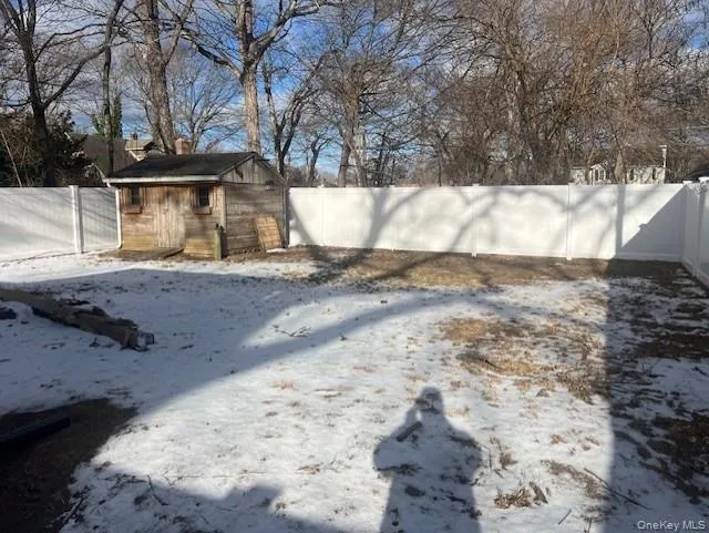 Snowy yard with a fenced backyard and a shed Snowy yard with a fenced backyard and a shed