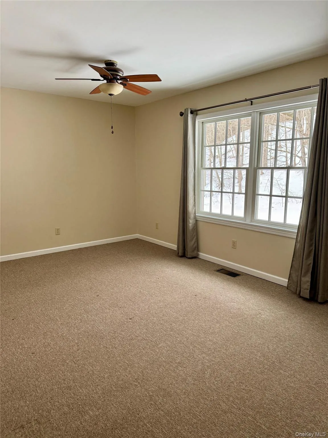 Empty room with light colored carpet and ceiling fan Empty room with light colored carpet and ceiling fan