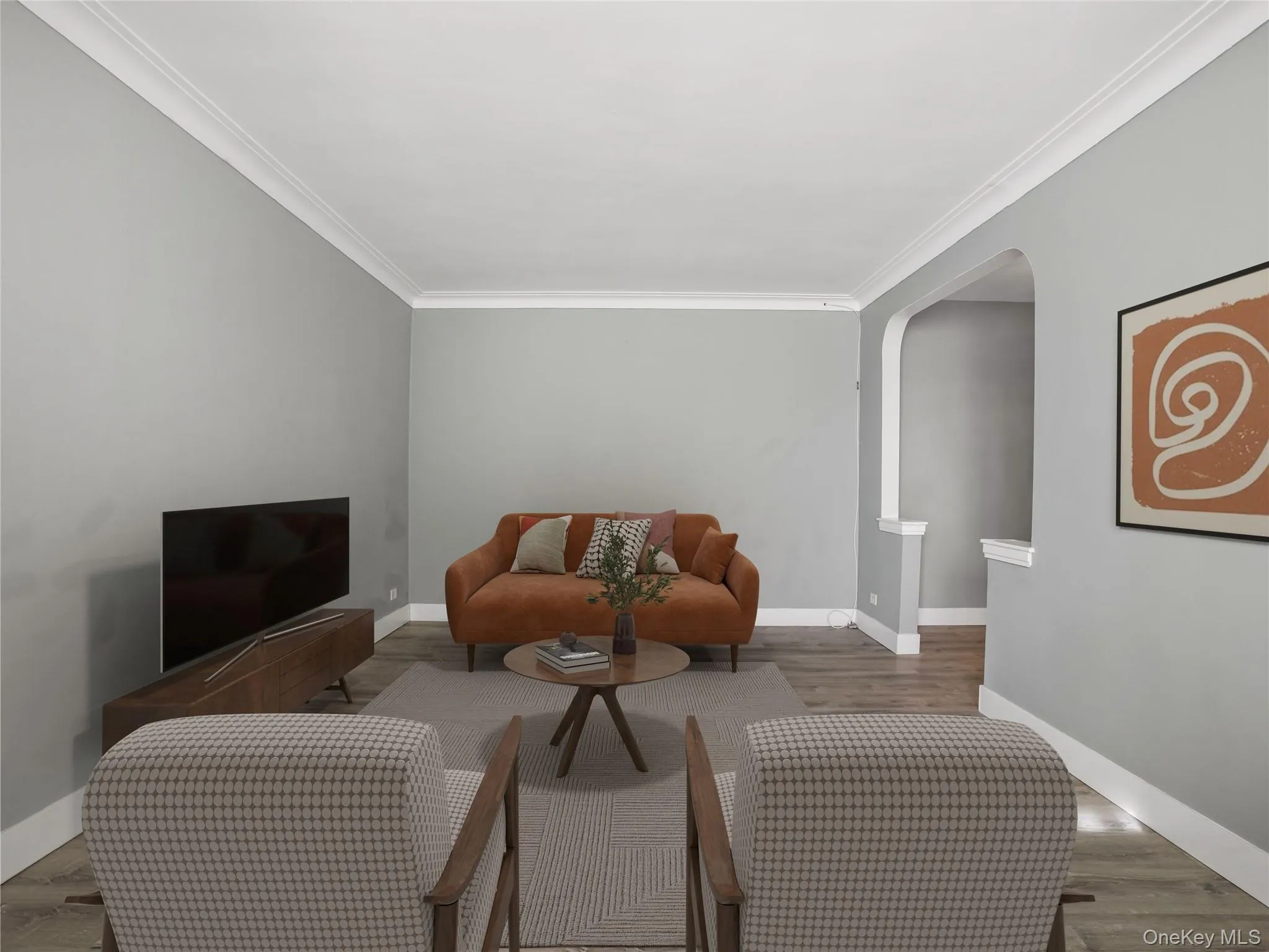 Living room with arched walkways, wood finished floors, and crown molding Living room with arched walkways, wood finished floors, and crown molding