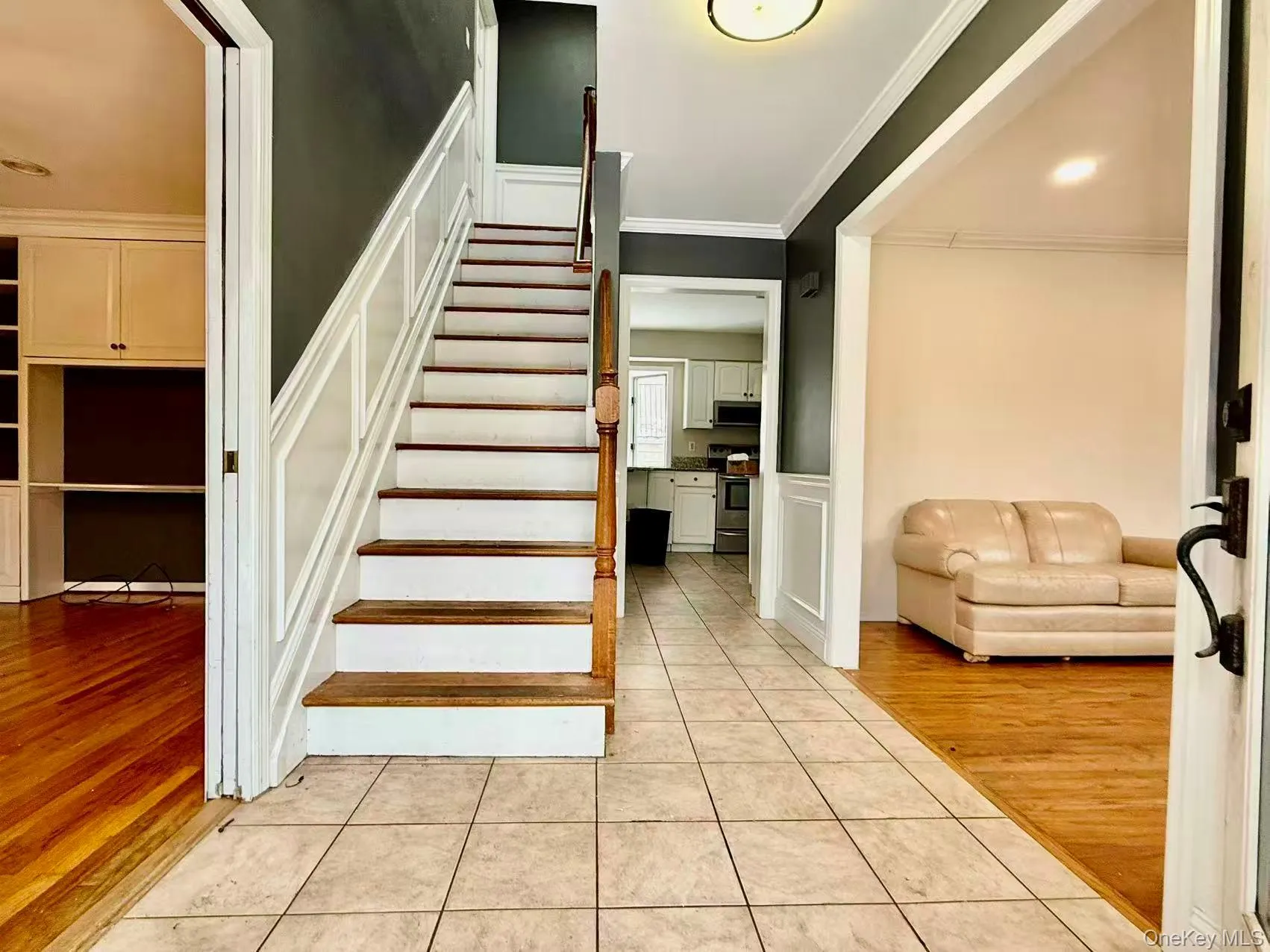 Staircase featuring tile patterned floors and ornamental molding Staircase featuring tile patterned floors and ornamental molding