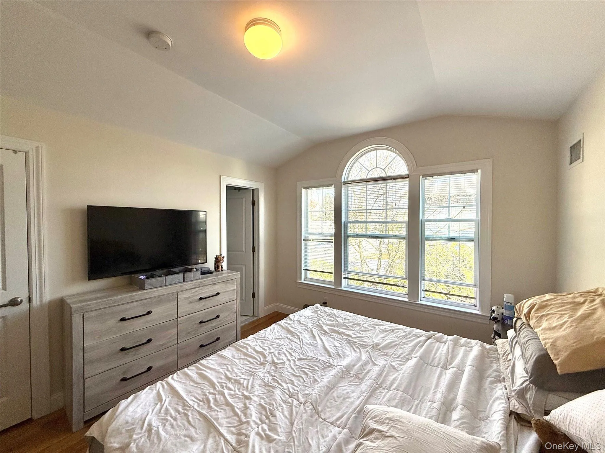 Bedroom with vaulted ceiling and wood finished floors Bedroom with vaulted ceiling and wood finished floors
