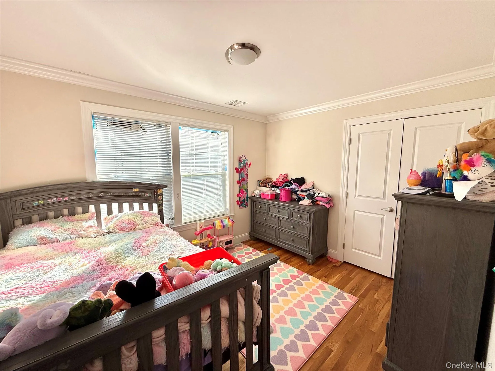 Bedroom featuring ornamental molding and light wood-style floors Bedroom featuring ornamental molding and light wood-style floors