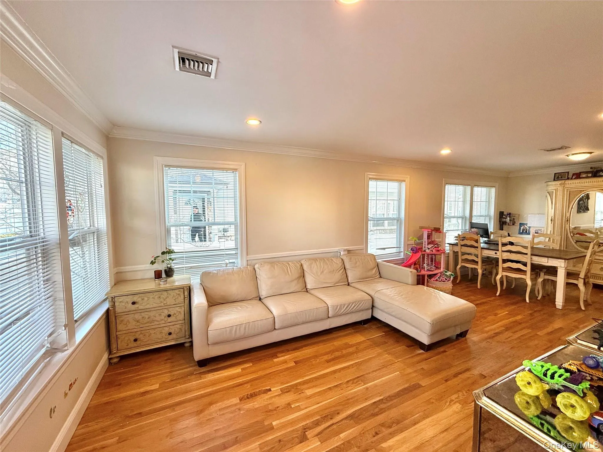 Living room with crown molding, light wood-style floors, and recessed lighting Living room with crown molding, light wood-style floors, and recessed lighting