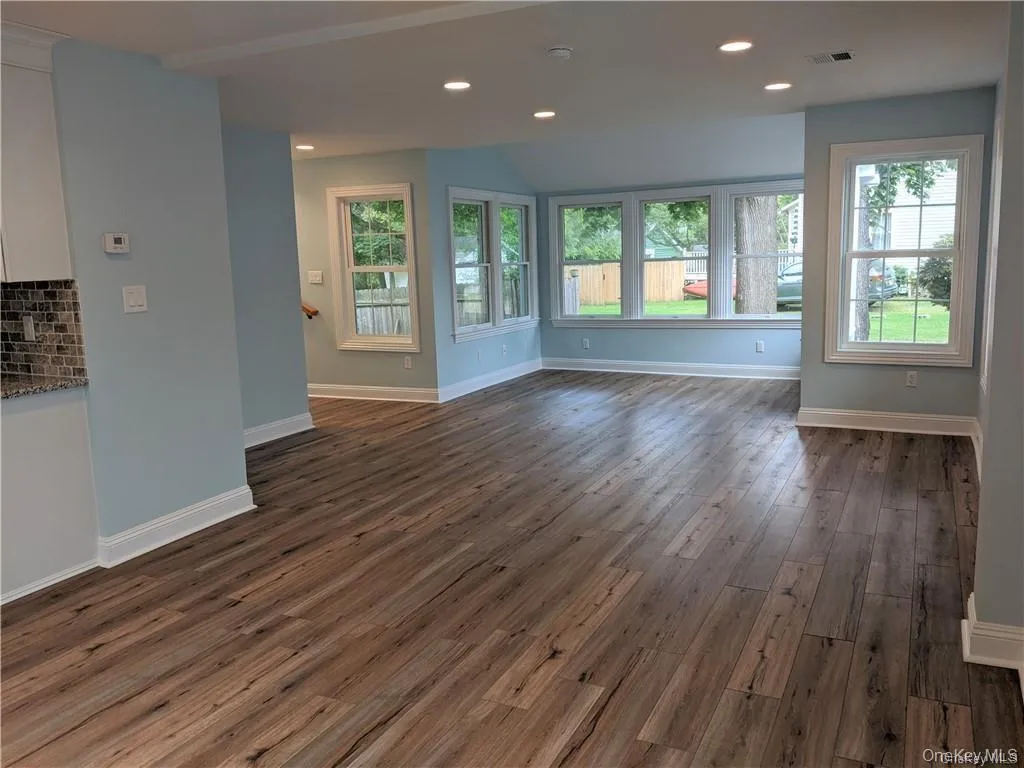 Another angle shows the main floor family room from the dining area. Windows surround the main level, making the space light and bright. The floors are all commercial grade luxury vinyl, beautiful yet durable! Another angle shows the main floor family room from the dining area. Windows surround the main level, making the space light and bright. The floors are all commercial grade luxury vinyl, beautiful yet durable!