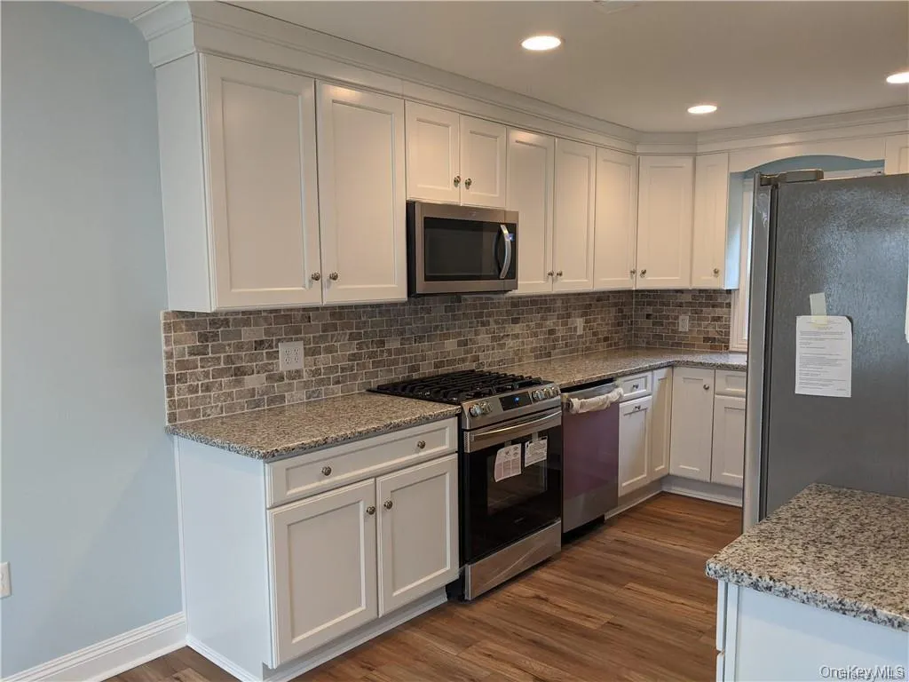 The updated kitchen features stainless appliances, granite counter-tops and gorgeous back-splash. The updated kitchen features stainless appliances, granite counter-tops and gorgeous back-splash.
