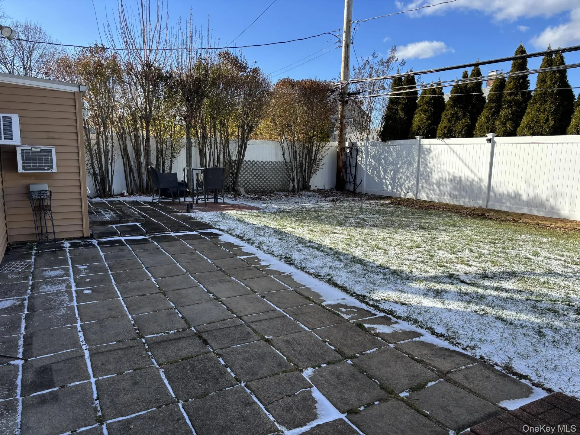 Fenced backyard featuring a patio area and a wall mounted air conditioner Fenced backyard featuring a patio area and a wall mounted air conditioner