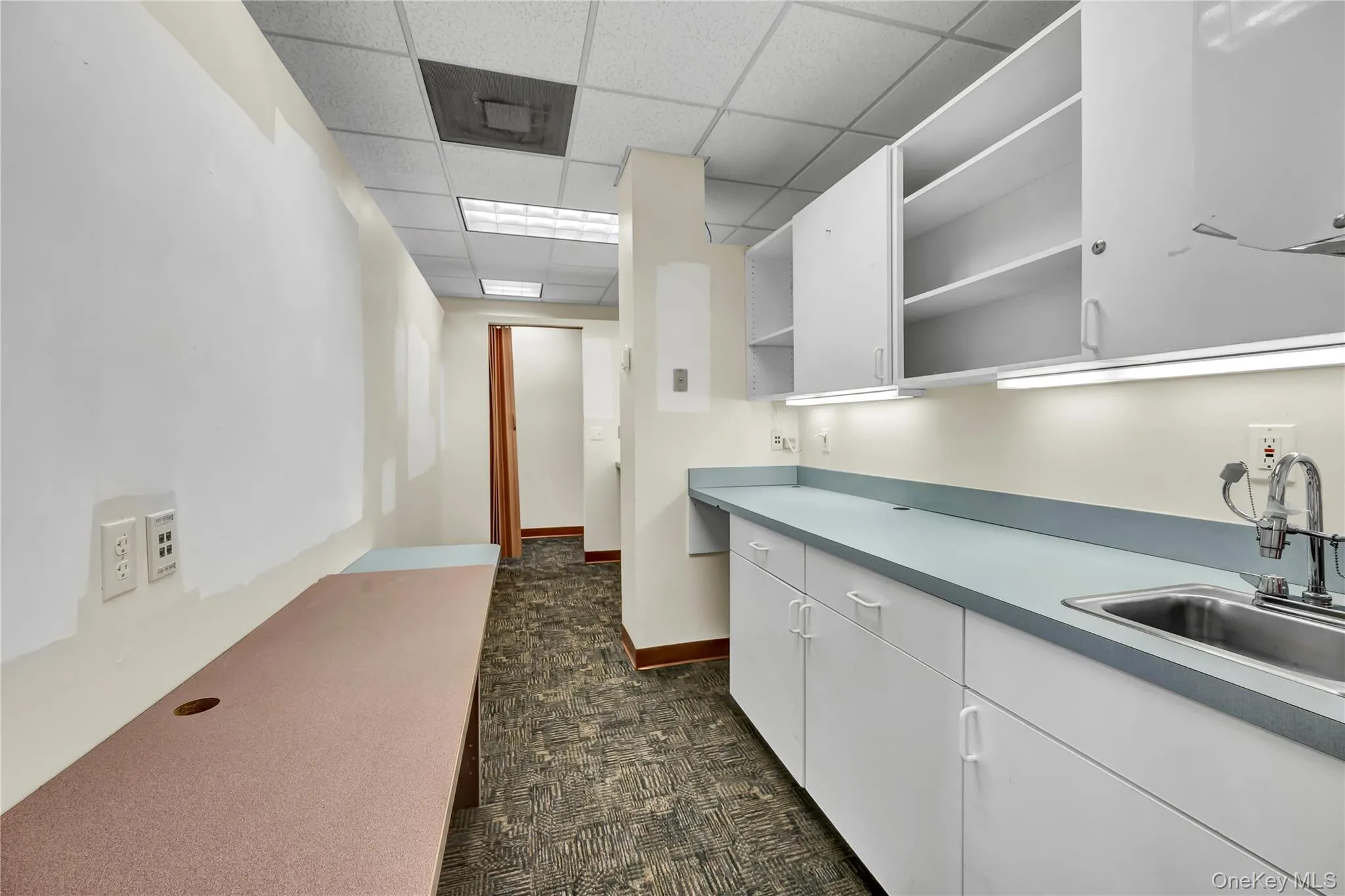 Kitchen featuring open shelves, white cabinetry, and a drop ceiling Kitchen featuring open shelves, white cabinetry, and a drop ceiling