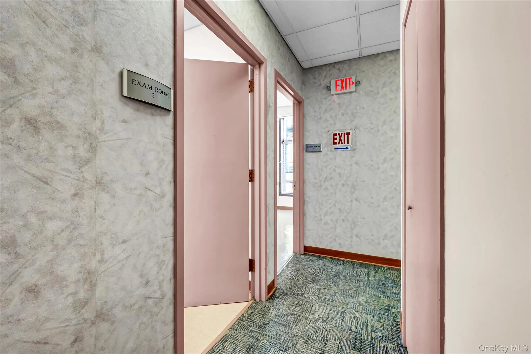 Corridor with carpet flooring and a paneled ceiling Corridor with carpet flooring and a paneled ceiling