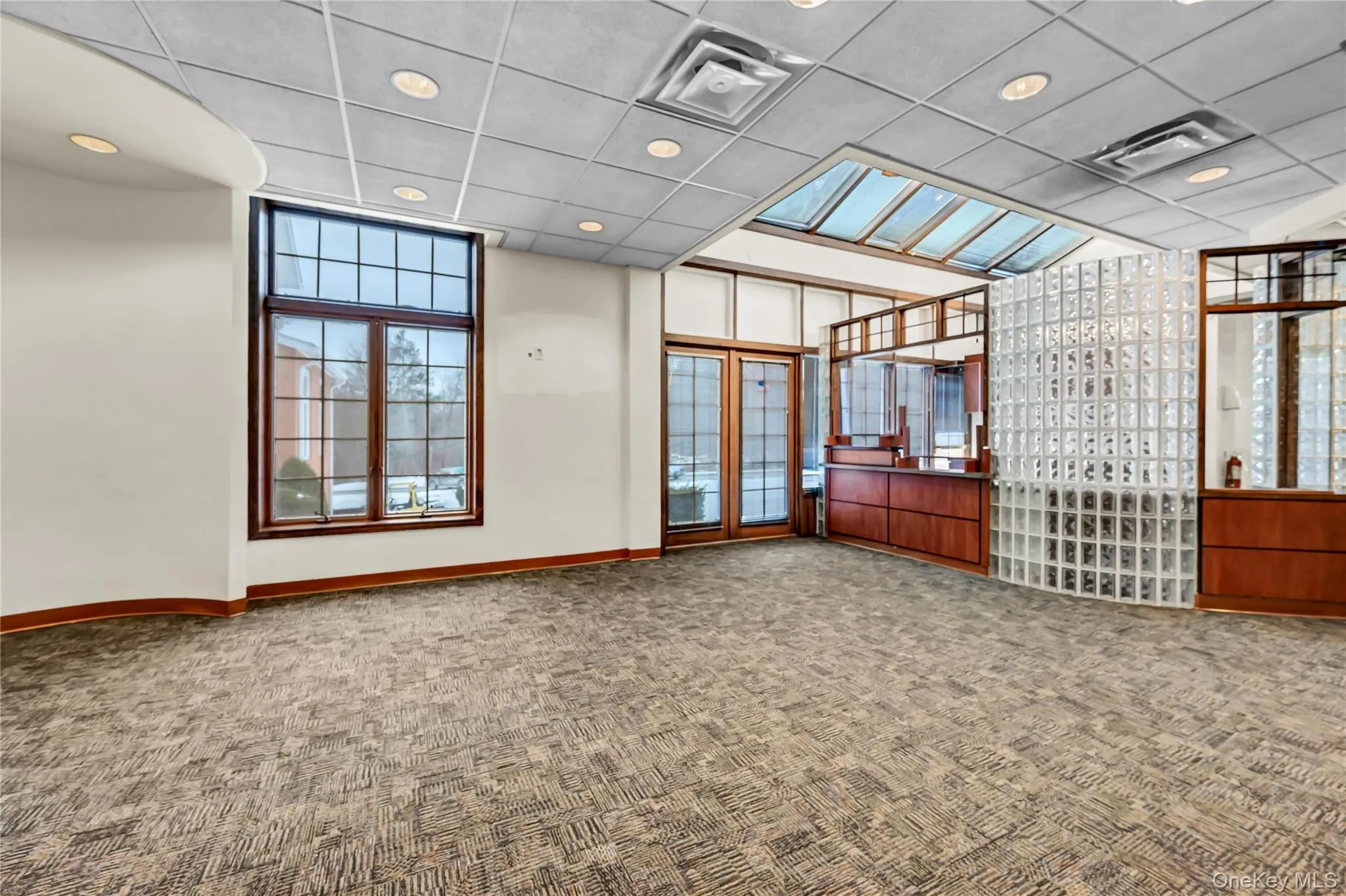 Unfurnished room with a drop ceiling, recessed lighting, and carpet Unfurnished room with a drop ceiling, recessed lighting, and carpet