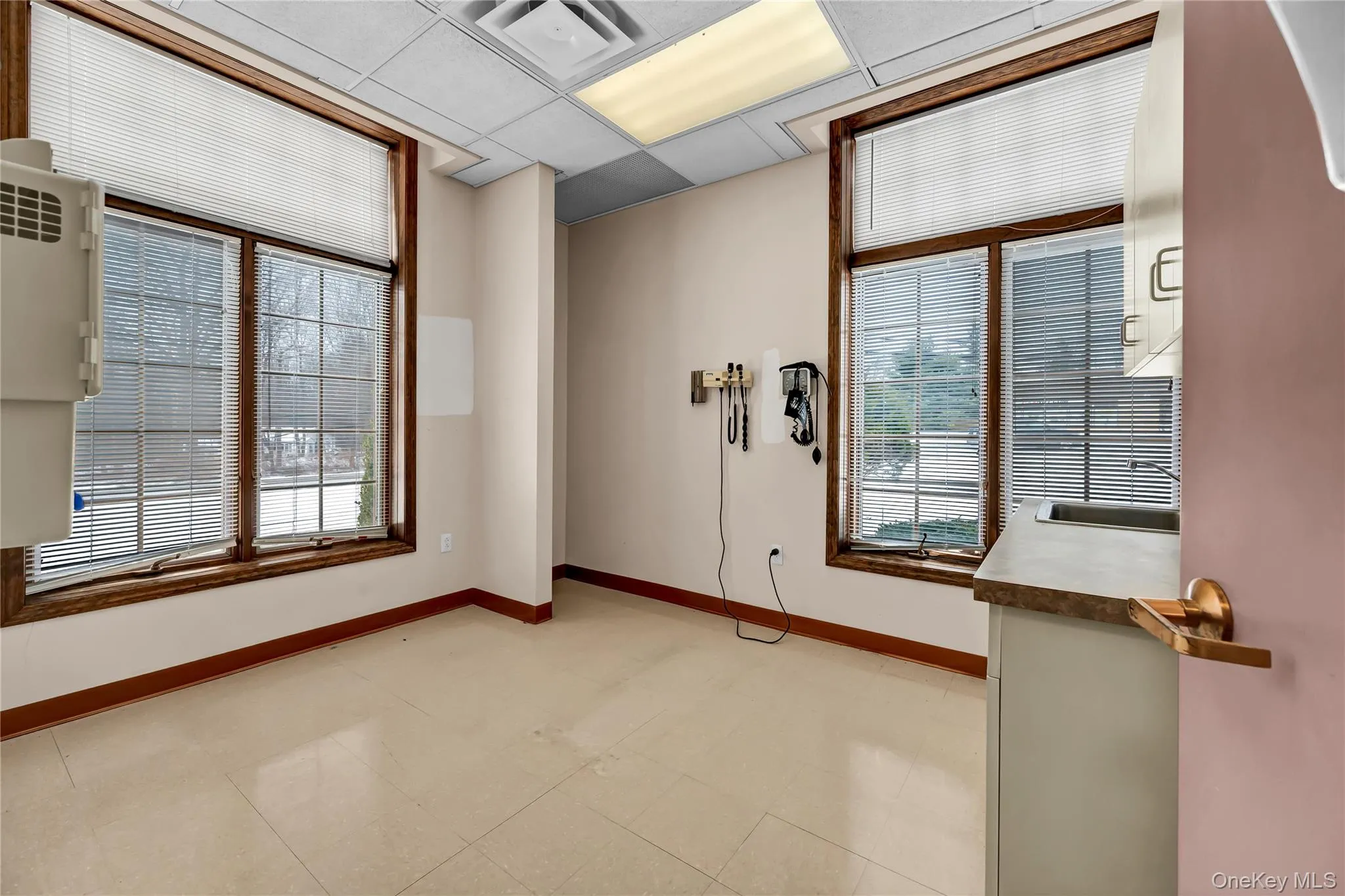 Empty room with a paneled ceiling, healthy amount of natural light, and light flooring Empty room with a paneled ceiling, healthy amount of natural light, and light flooring