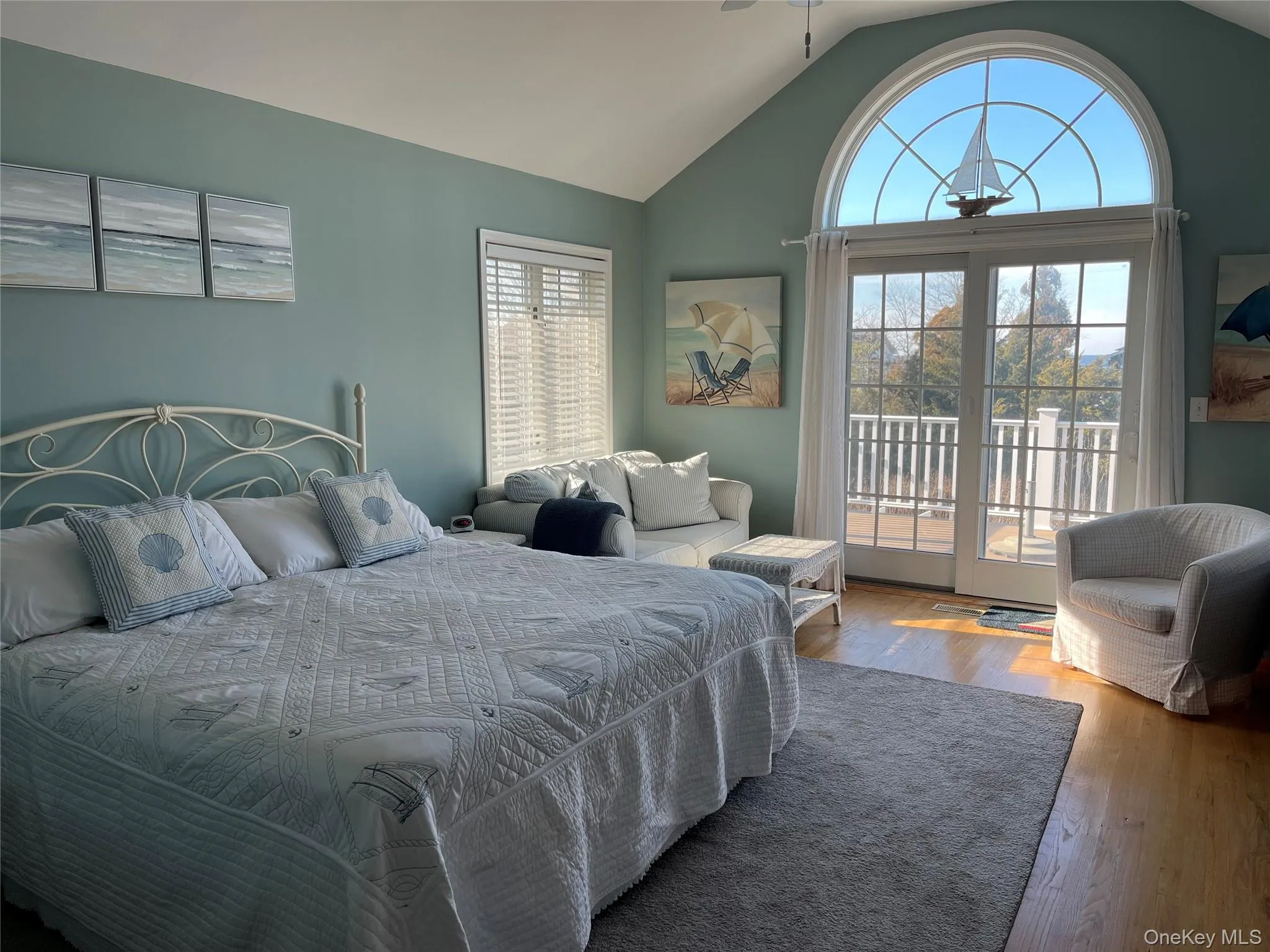 Bedroom featuring access to exterior, vaulted ceiling, and wood finished floors Bedroom featuring access to exterior, vaulted ceiling, and wood finished floors