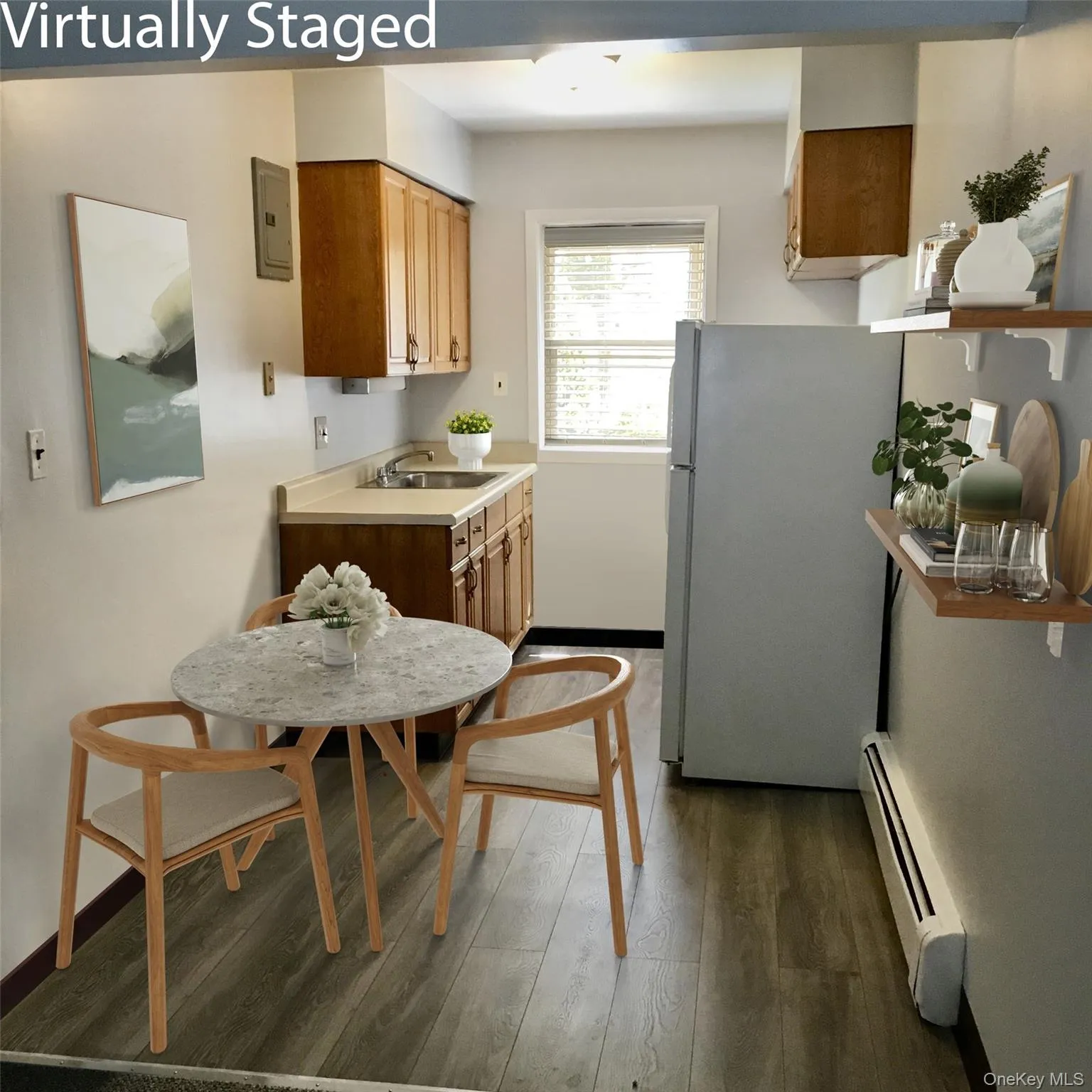 Kitchen featuring light countertops, freestanding refrigerator, baseboard heating, dark wood-style floors, and brown cabinets Kitchen featuring light countertops, freestanding refrigerator, baseboard heating, dark wood-style floors, and brown cabinets