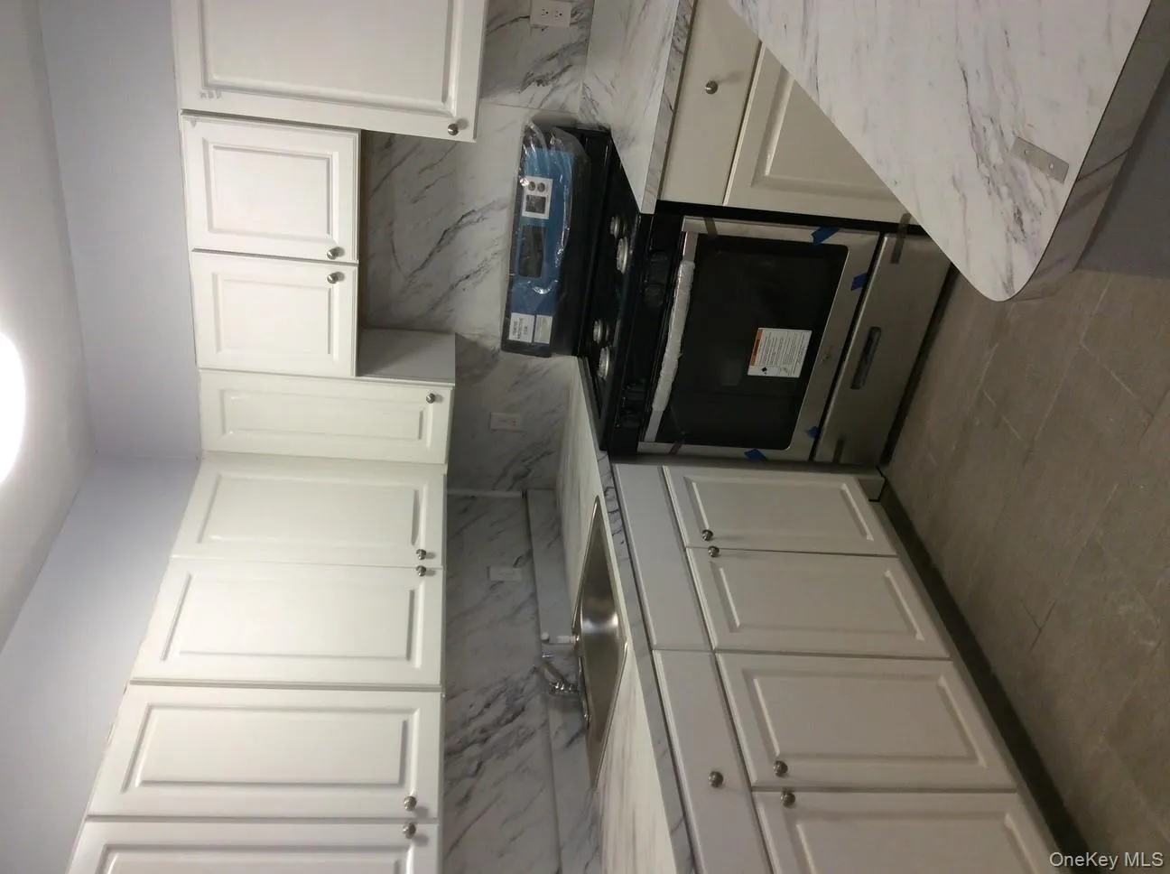 Kitchen with white cabinets, stainless steel electric range, light countertops, and backsplash Kitchen with white cabinets, stainless steel electric range, light countertops, and backsplash