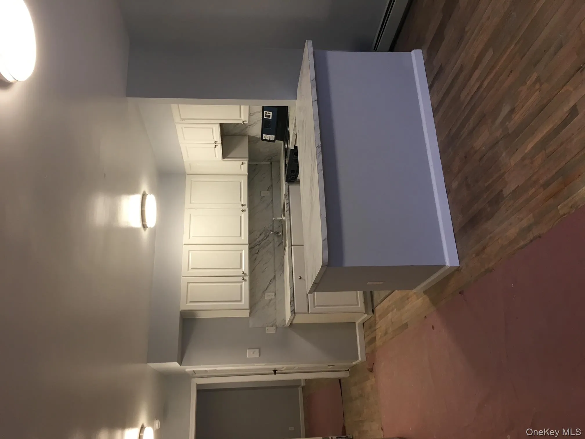 Kitchen with white cabinetry, range, dark wood-style flooring, and a baseboard heating unit Kitchen with white cabinetry, range, dark wood-style flooring, and a baseboard heating unit
