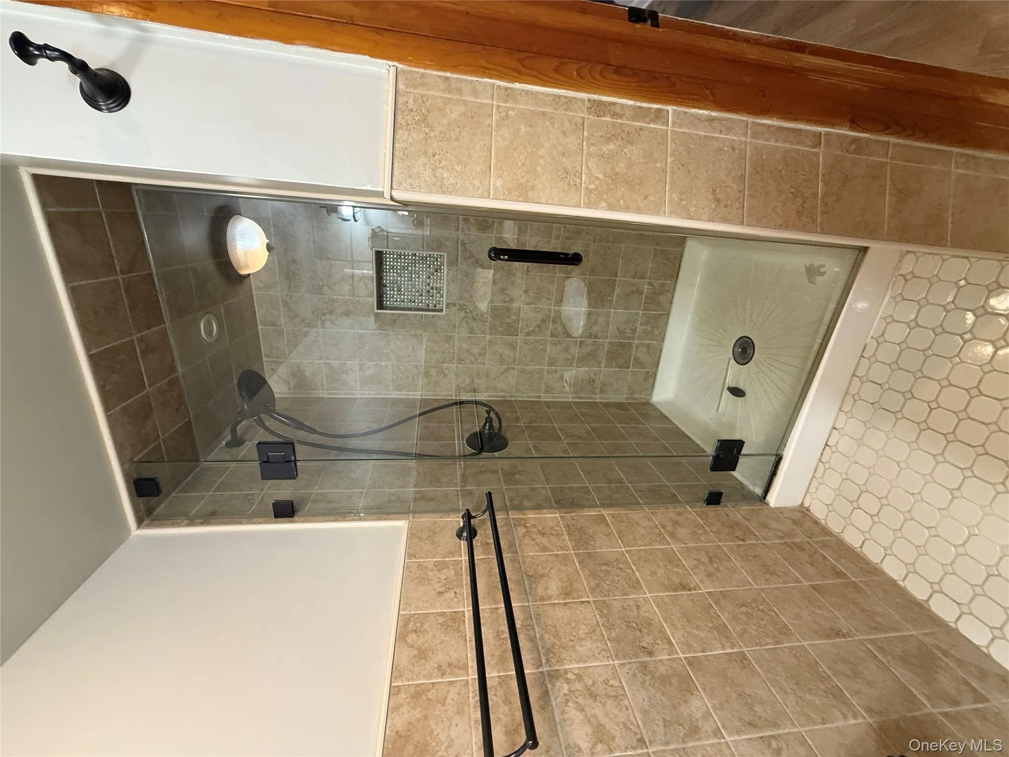 Bathroom with a shower stall and tile walls Bathroom with a shower stall and tile walls