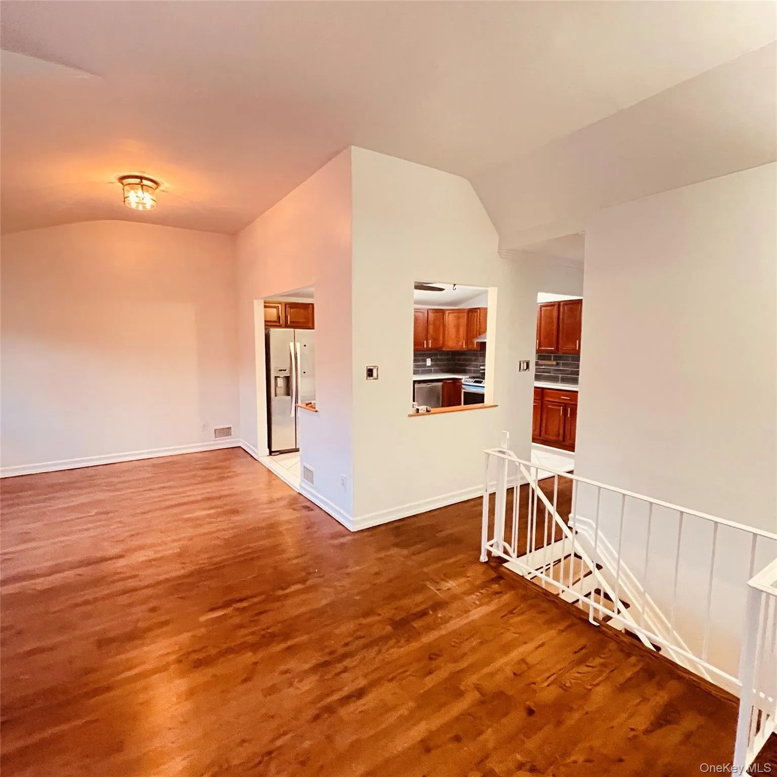 Empty room with vaulted ceiling and dark wood-style floors Empty room with vaulted ceiling and dark wood-style floors