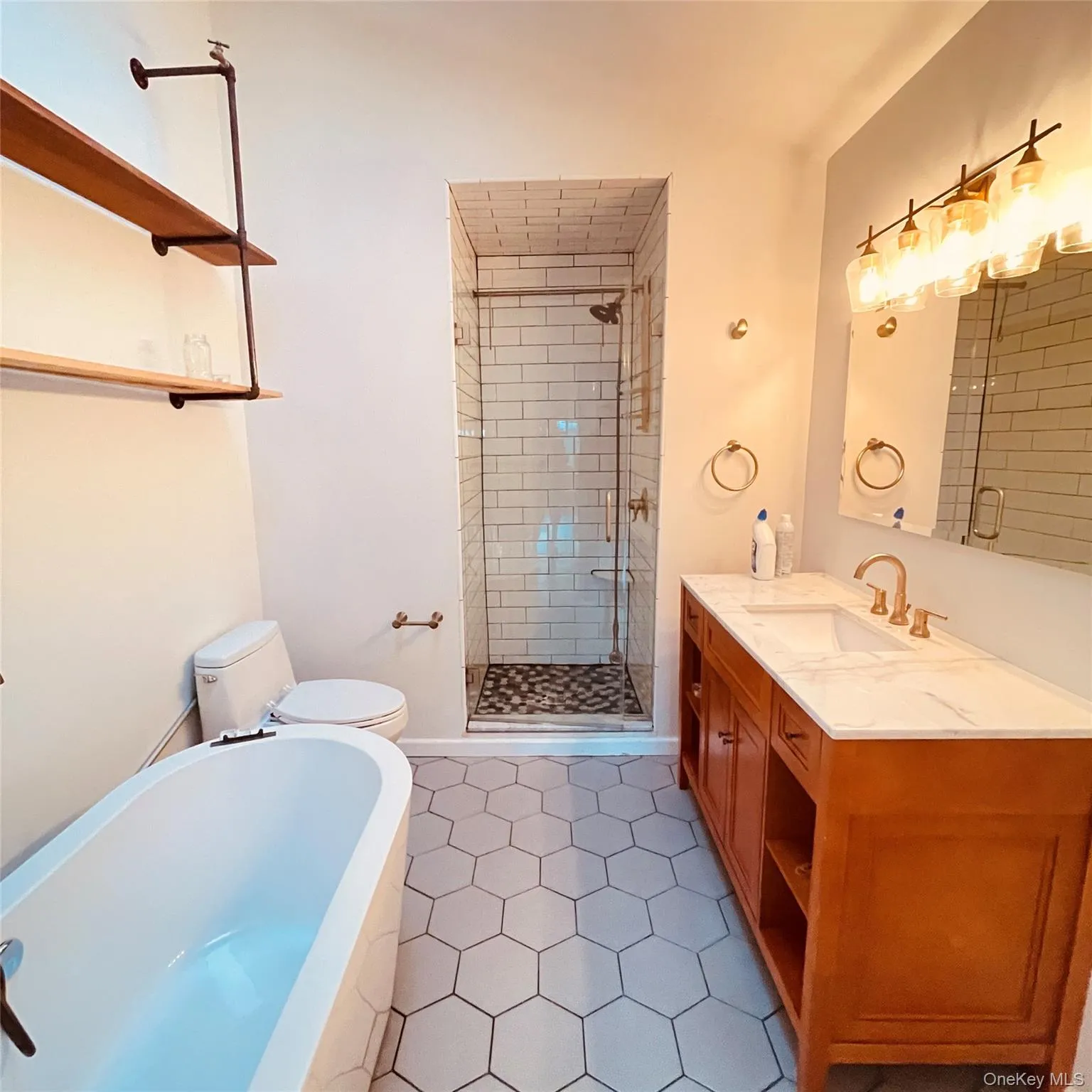 Full bath featuring a tub, vanity, a stall shower, and dark tile patterned floors Full bath featuring a tub, vanity, a stall shower, and dark tile patterned floors