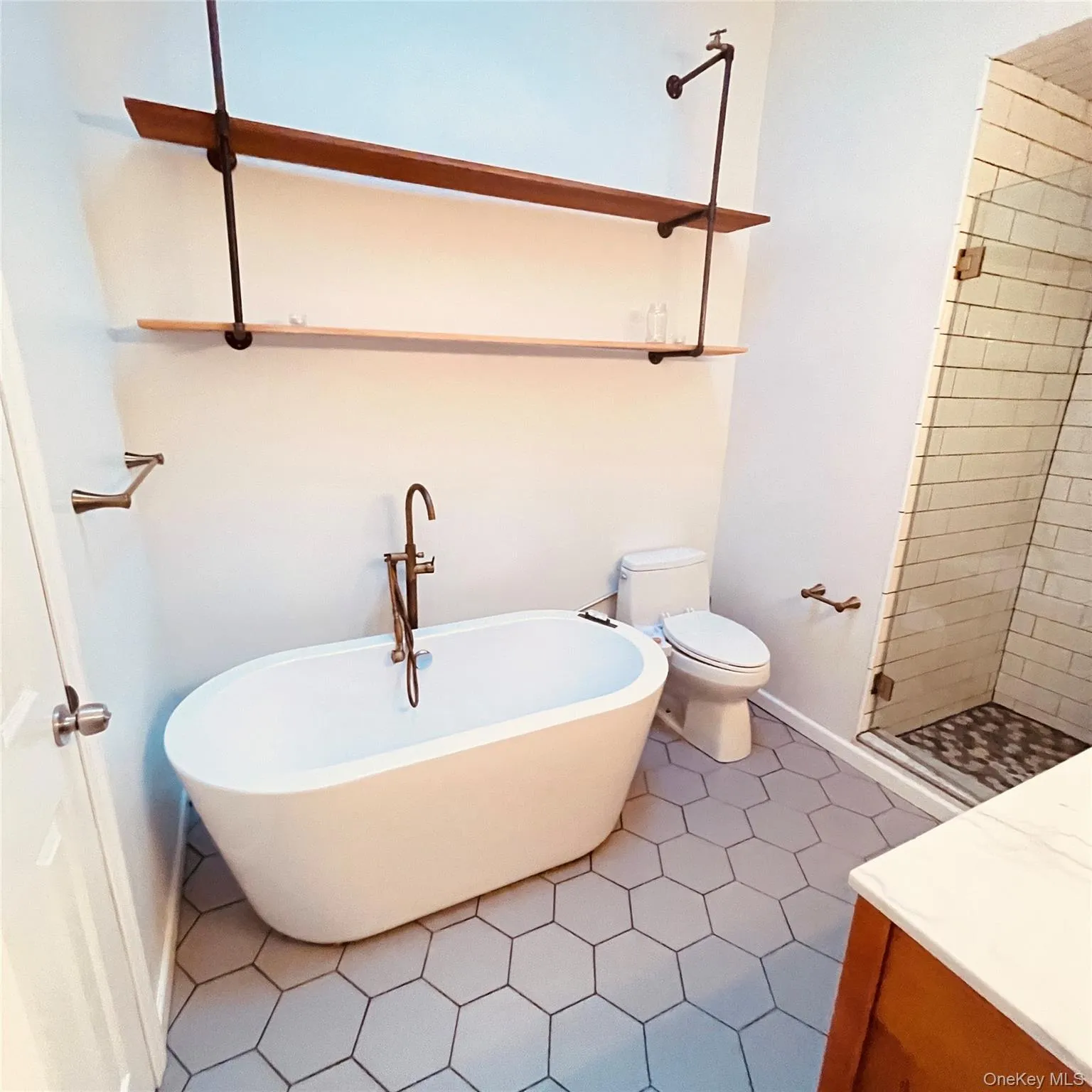 Full bath featuring a soaking tub, a shower stall, and dark tile patterned floors Full bath featuring a soaking tub, a shower stall, and dark tile patterned floors