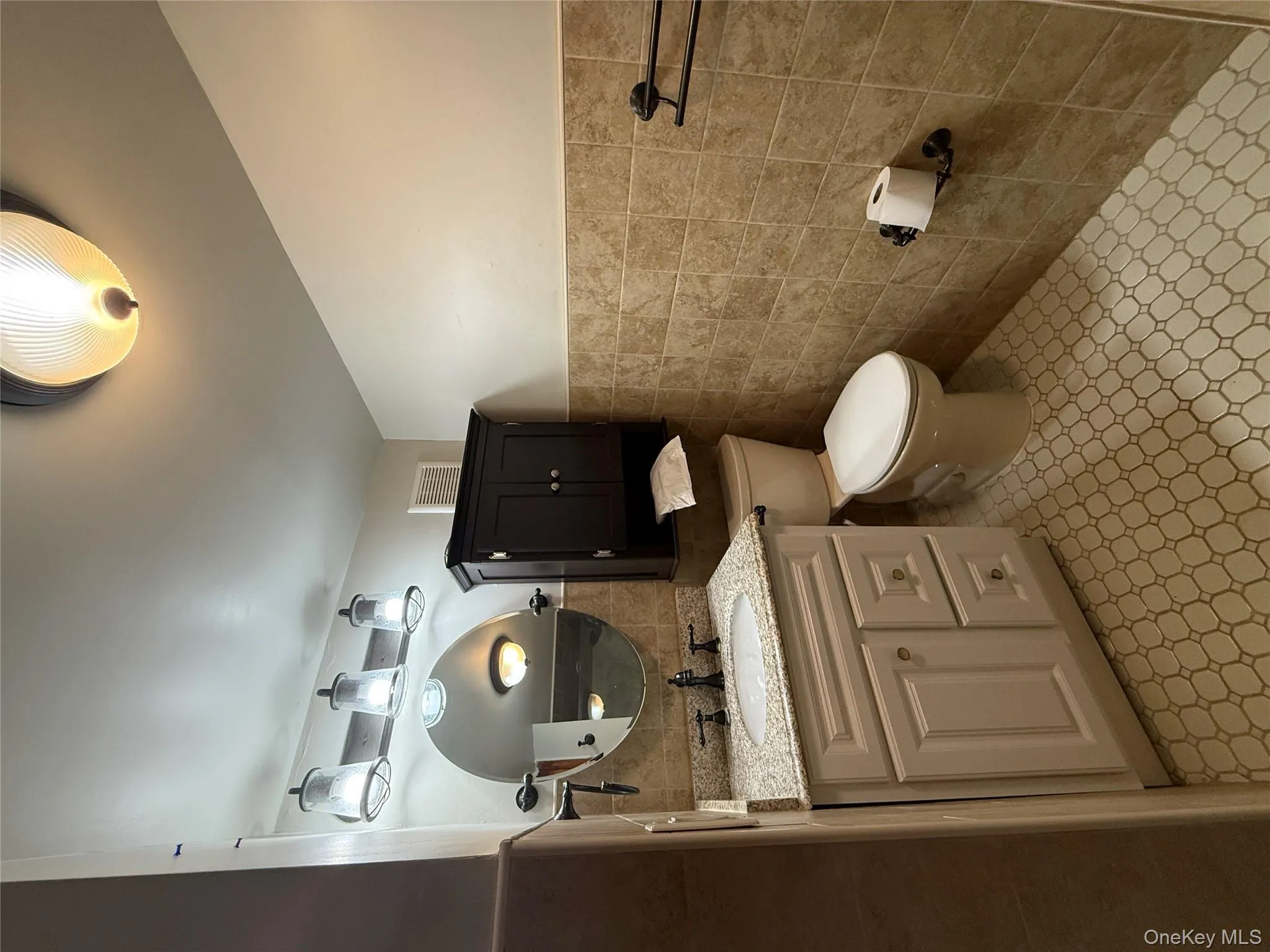 Half bath with wainscoting, vanity, and tile walls Half bath with wainscoting, vanity, and tile walls