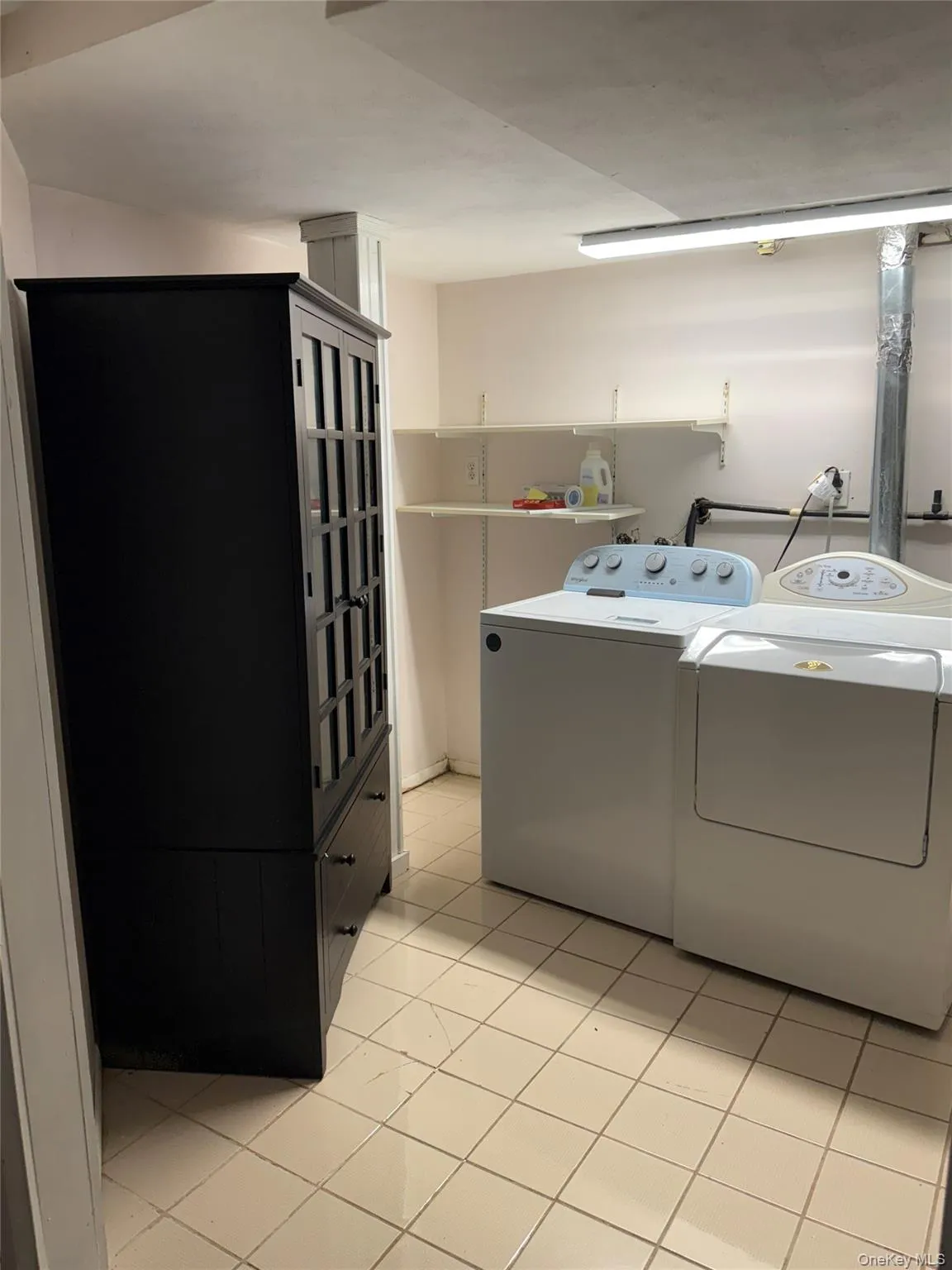 Washroom with separate washer and dryer and light tile patterned floors Washroom with separate washer and dryer and light tile patterned floors