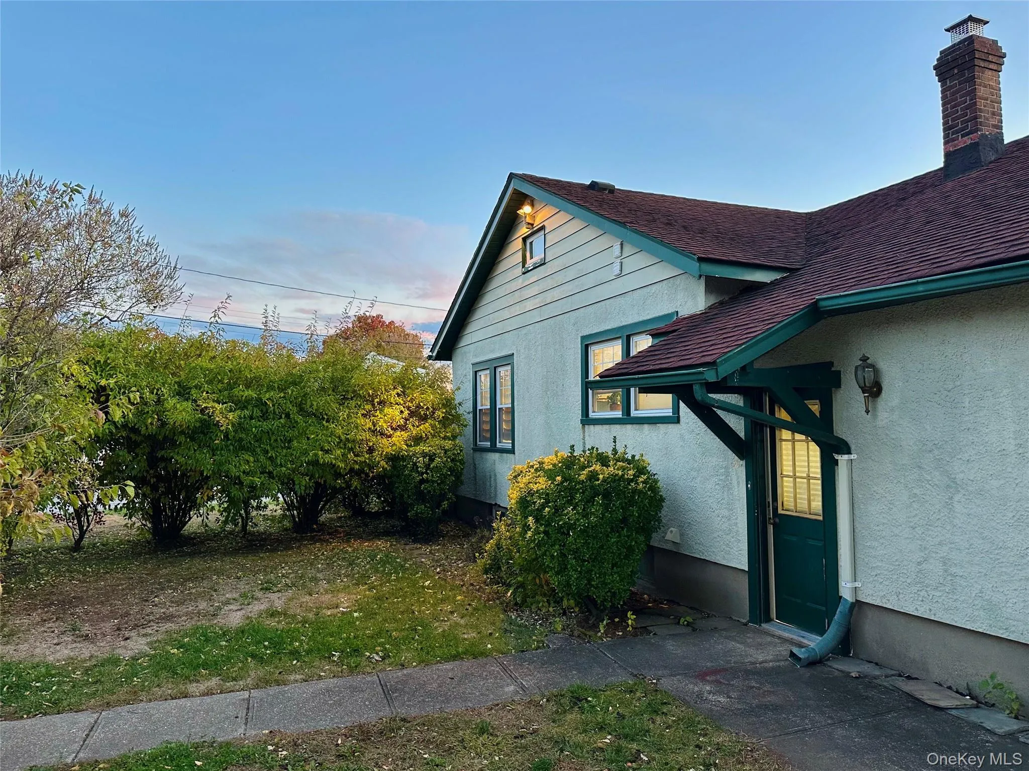 View of side of home with stucco siding and a chimney View of side of home with stucco siding and a chimney
