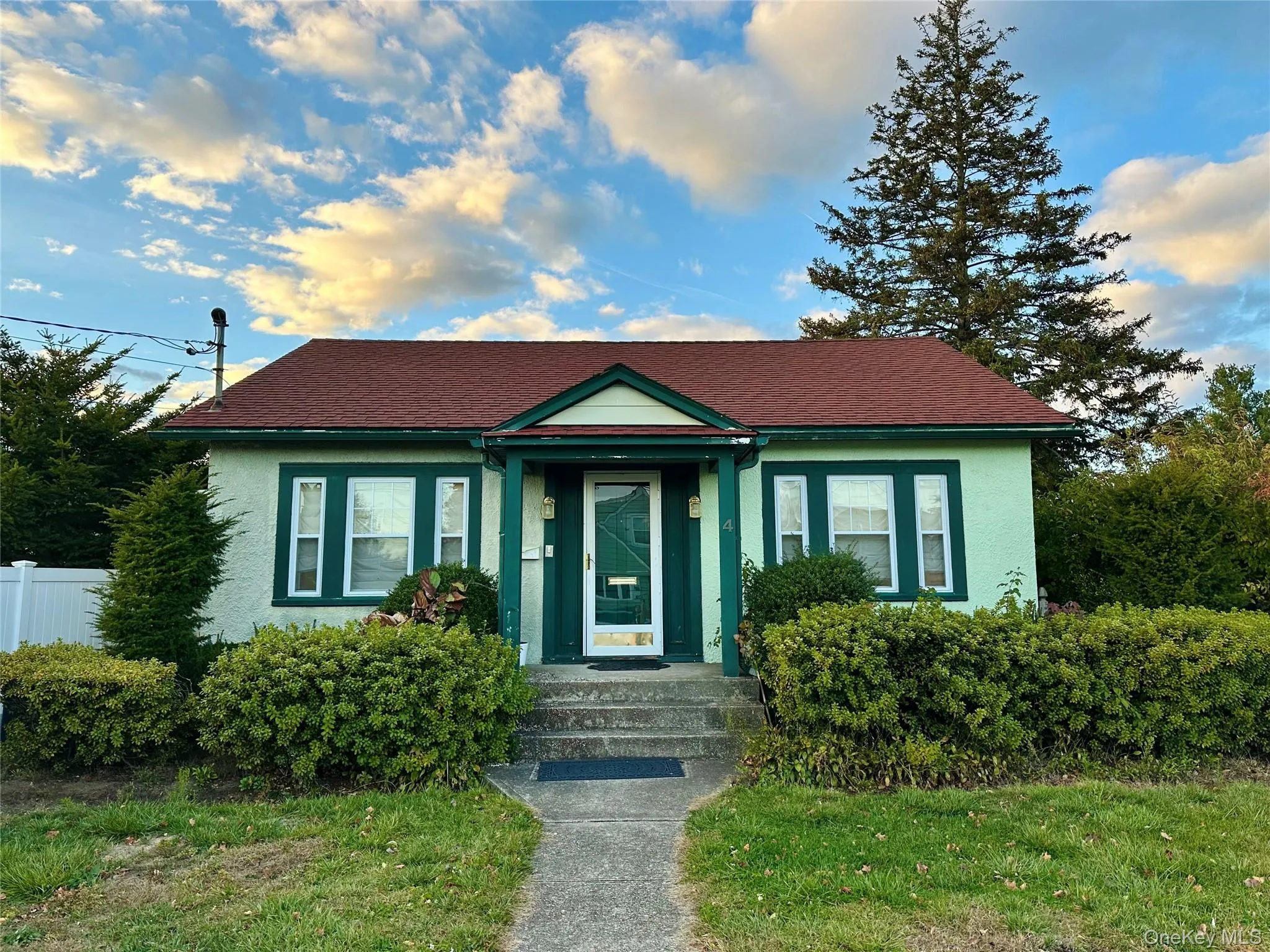 Bungalow featuring stucco siding and a shingled roof Bungalow featuring stucco siding and a shingled roof