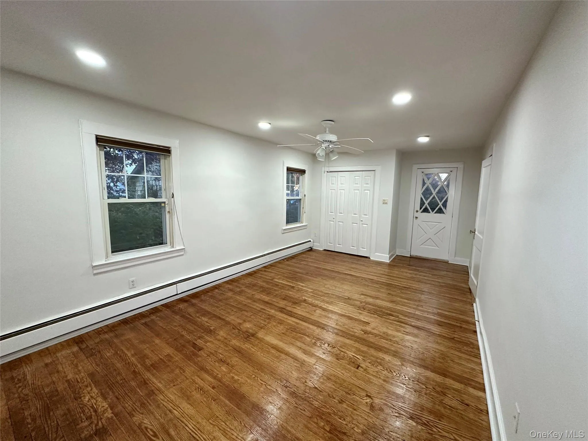Unfurnished room with baseboard heating, hardwood / wood-style floors, recessed lighting, and a ceiling fan Unfurnished room with baseboard heating, hardwood / wood-style floors, recessed lighting, and a ceiling fan
