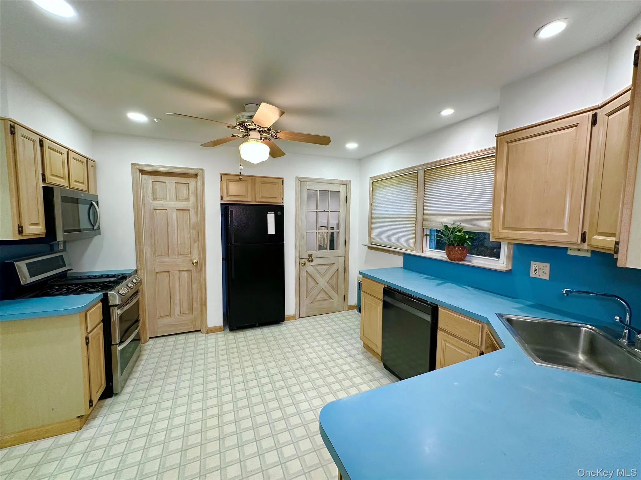 Kitchen featuring light floors, light brown cabinetry, black appliances, ceiling fan, and recessed lighting Kitchen featuring light floors, light brown cabinetry, black appliances, ceiling fan, and recessed lighting
