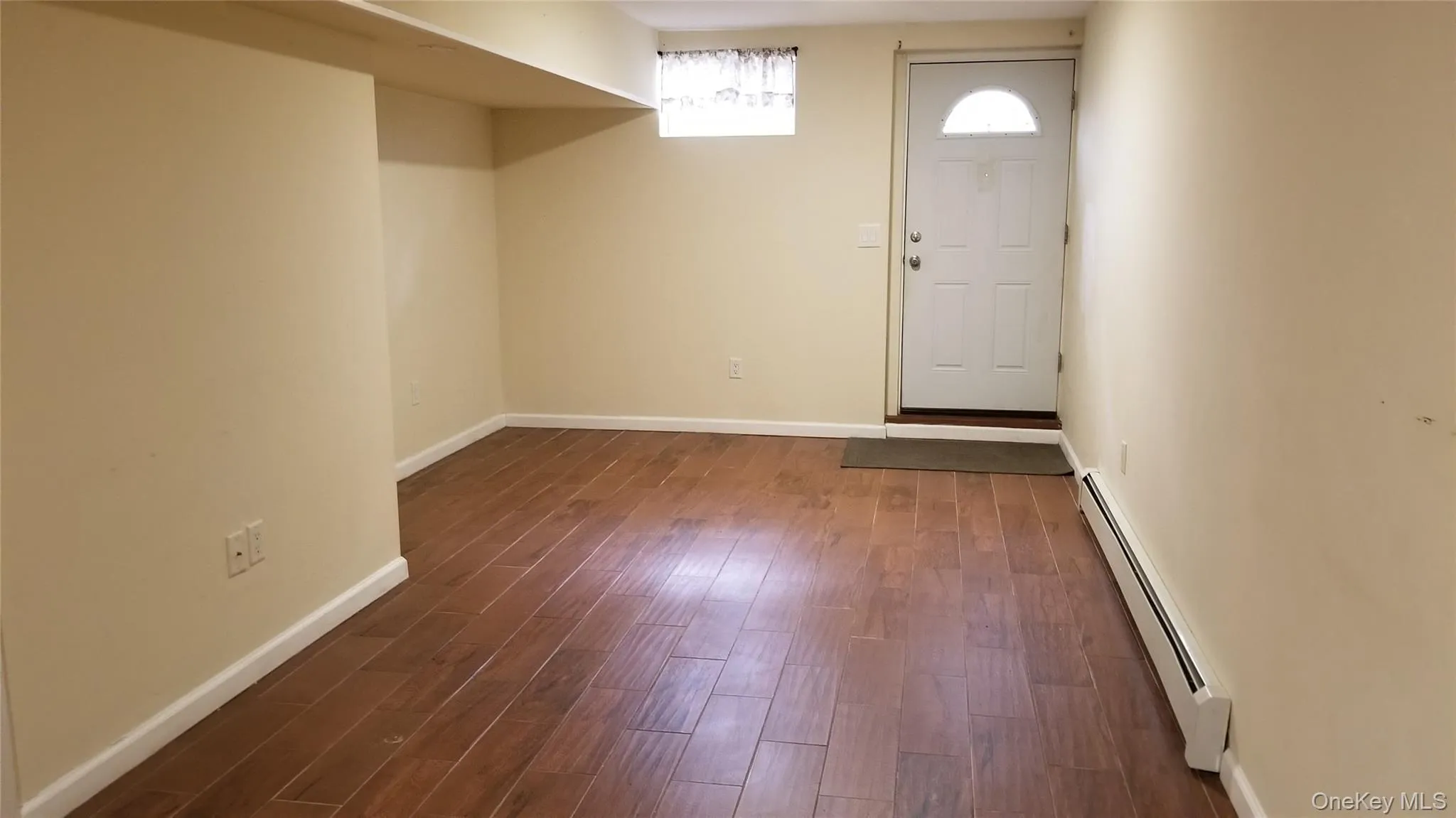 Entryway with baseboard heating and dark wood-style floors Entryway with baseboard heating and dark wood-style floors