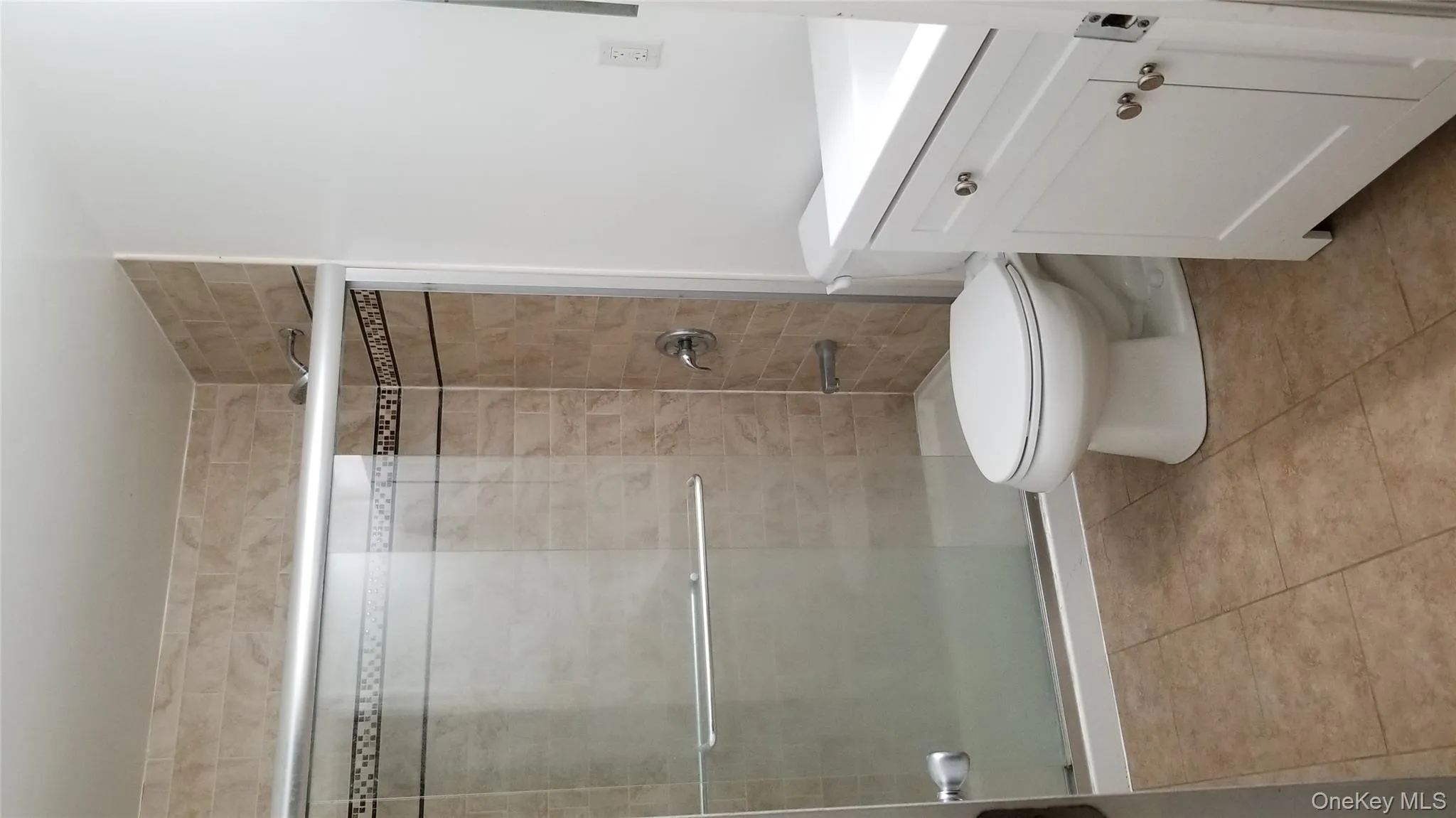 Bathroom with vanity, a shower stall, and light tile patterned flooring Bathroom with vanity, a shower stall, and light tile patterned flooring