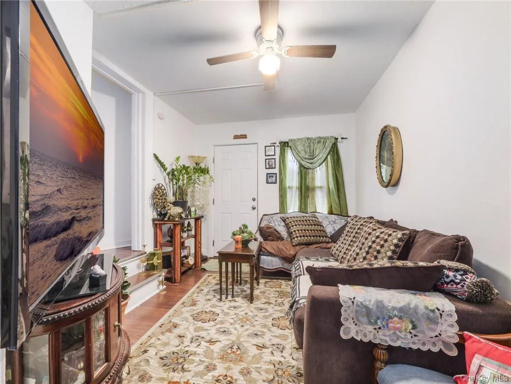 Living area featuring wood finished floors and a ceiling fan Living area featuring wood finished floors and a ceiling fan