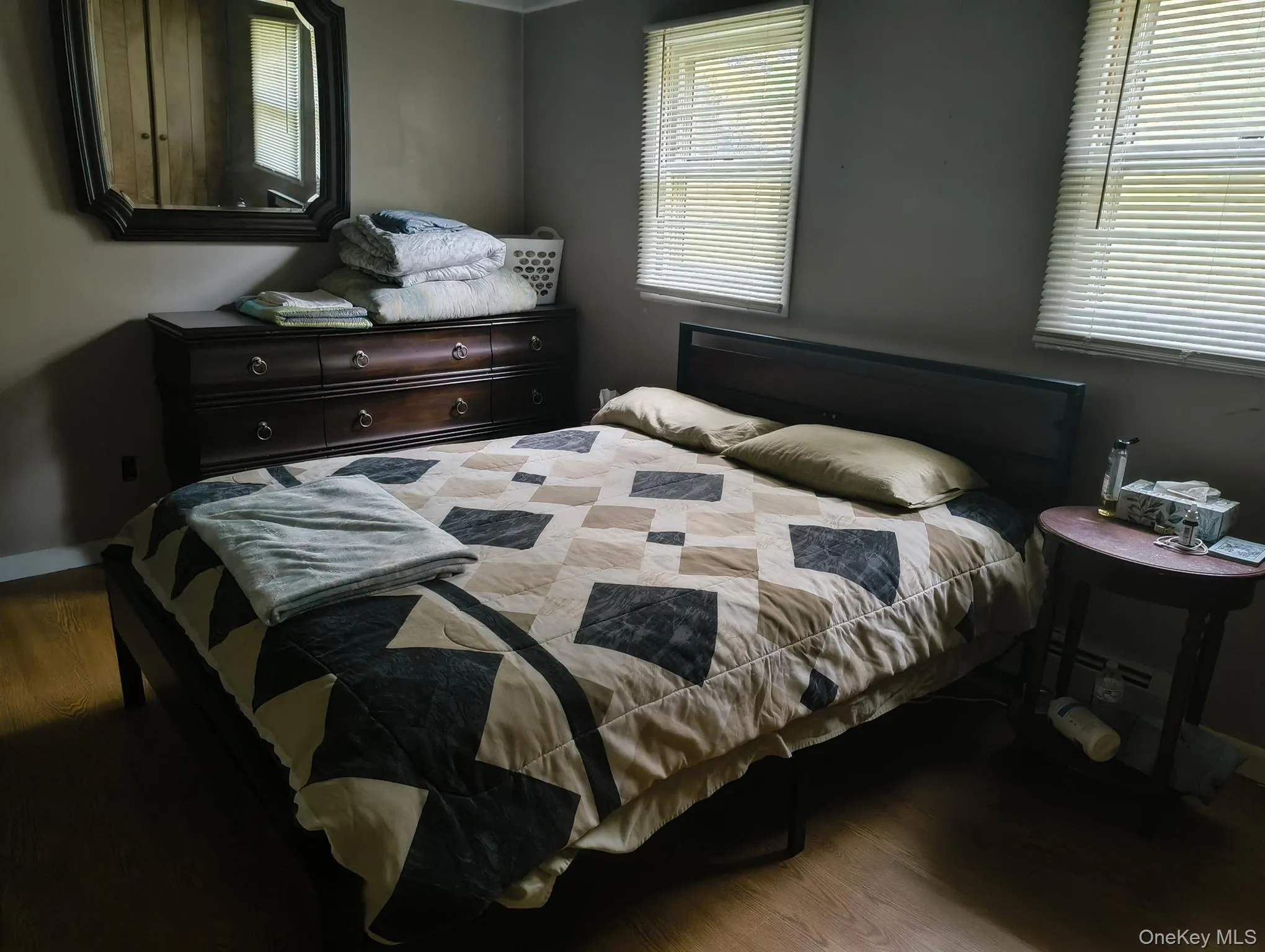 Bedroom with wood finished floors and multiple windows Bedroom with wood finished floors and multiple windows