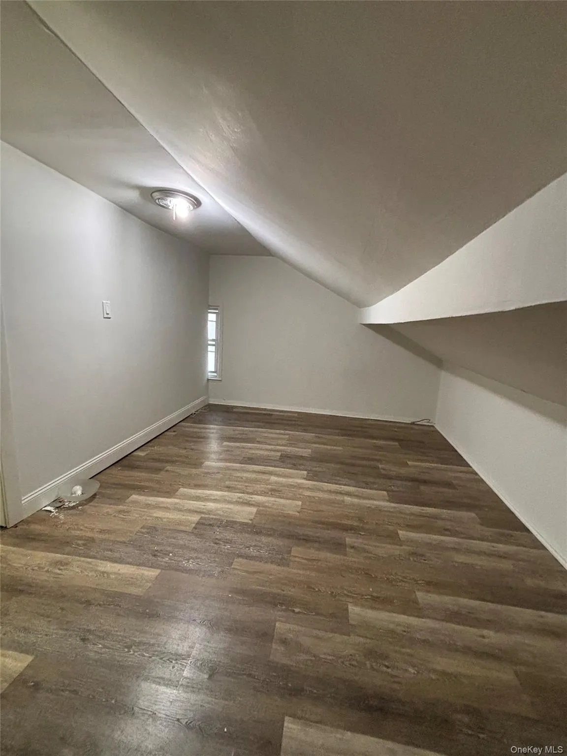 Additional living space featuring lofted ceiling and dark wood finished floors Additional living space featuring lofted ceiling and dark wood finished floors