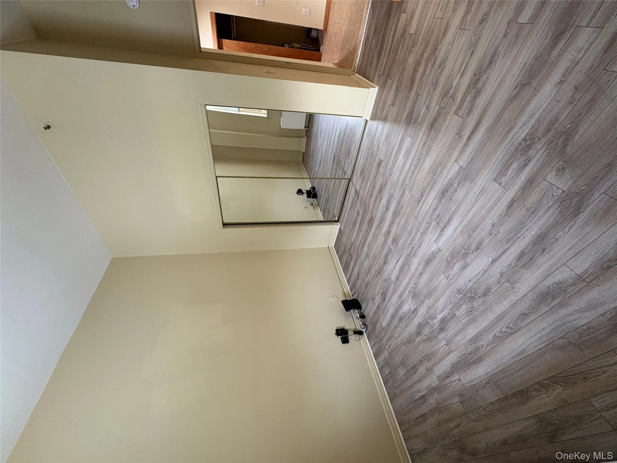 Unfurnished bedroom with high vaulted ceiling, wood finished floors, and a closet Unfurnished bedroom with high vaulted ceiling, wood finished floors, and a closet